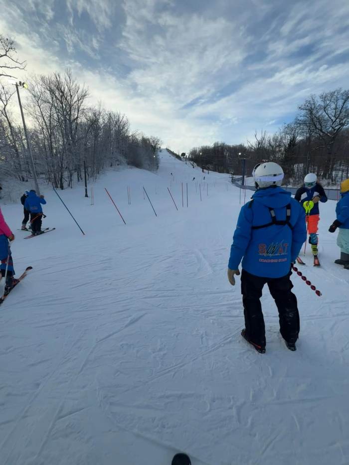 Athletes climbing back up a slalom course on an overcast training day