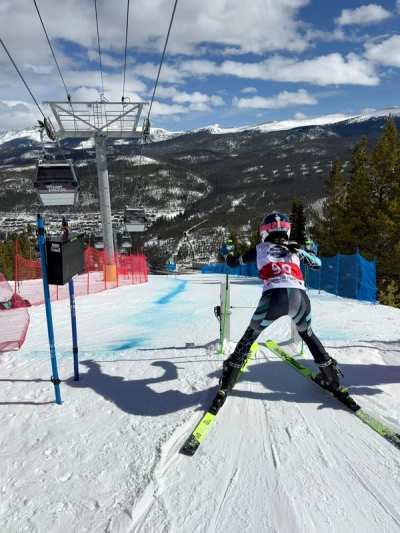 Racer leaving the start gate with the chairlift and hillside behind