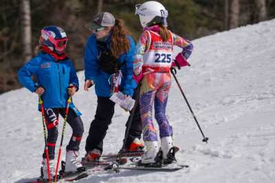 Coach talking through a run with athletes at the side of the course