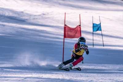 Racer between red and blue giant slalom panels on open snow