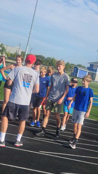 Athletes running intervals on an outdoor track during dryland training