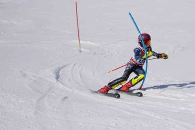 Young racer holding an edge through a slalom turn on a groomed pitch