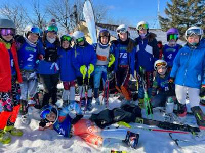 Large team group photo, athletes seated and standing with their skis