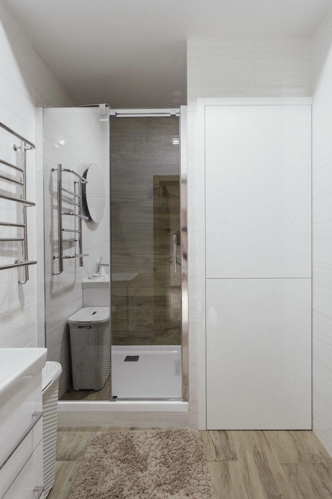 Secondo bagno con doccia, mobile lavabo bianco e specchio tondo