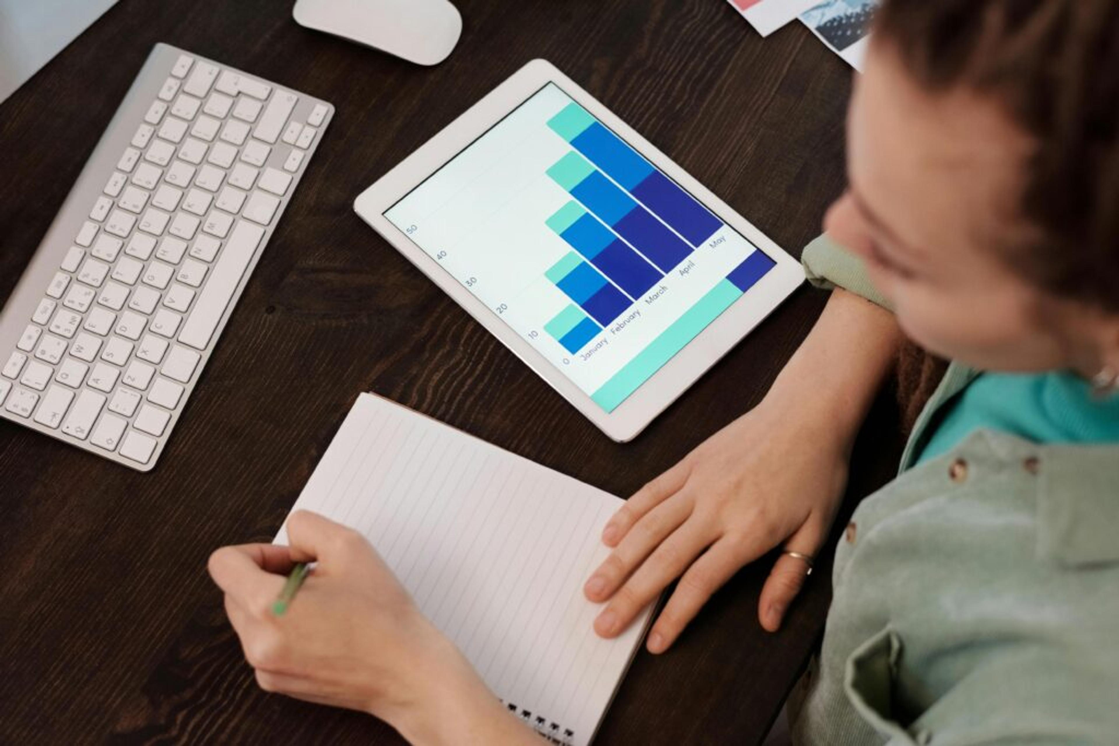 manos de mujer escribiendo técnicas de seguimiento de ventas en una libreta
