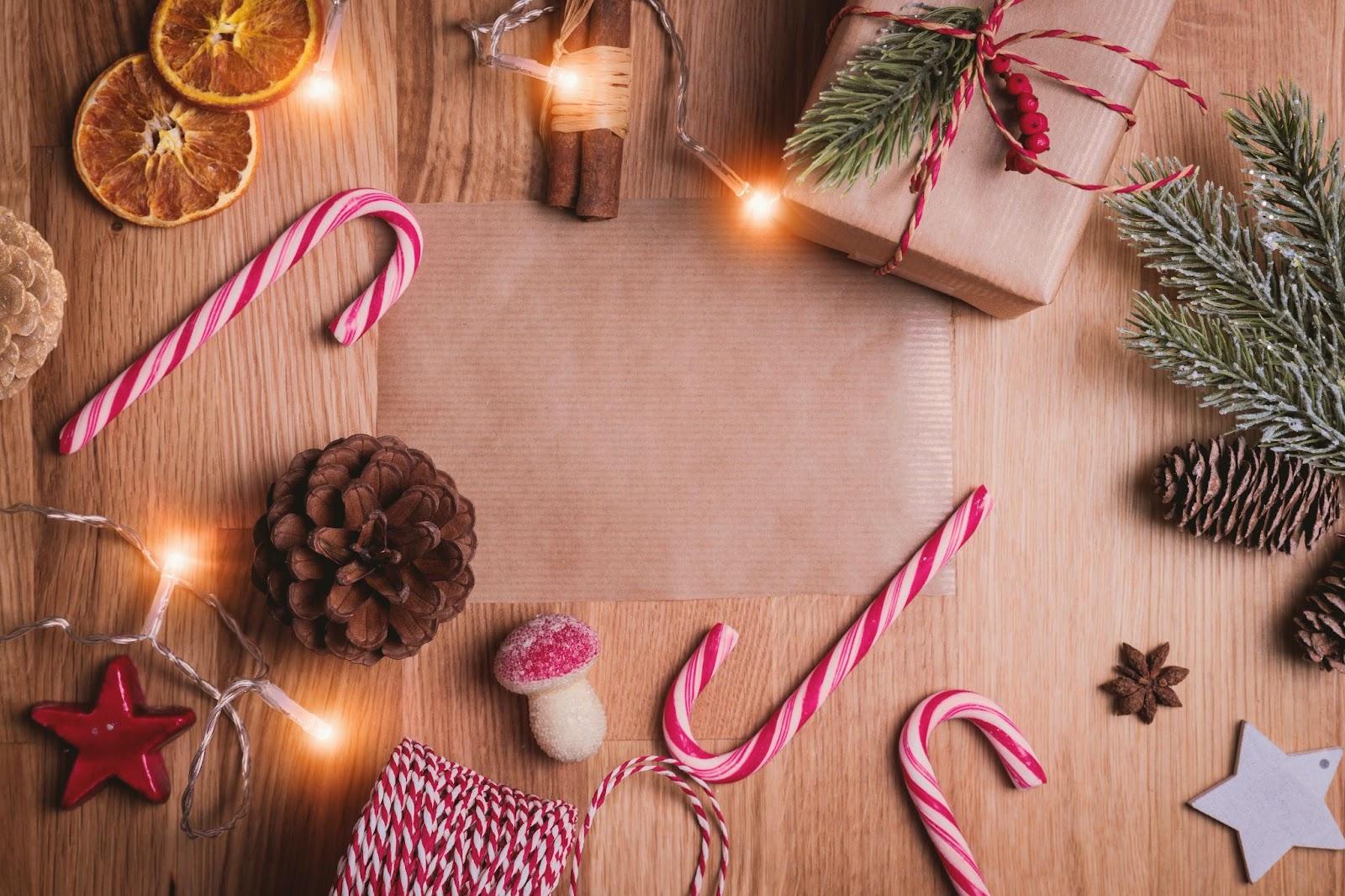 Bastones de caramelo, una caja de regalo, luces navideñas y coníferas