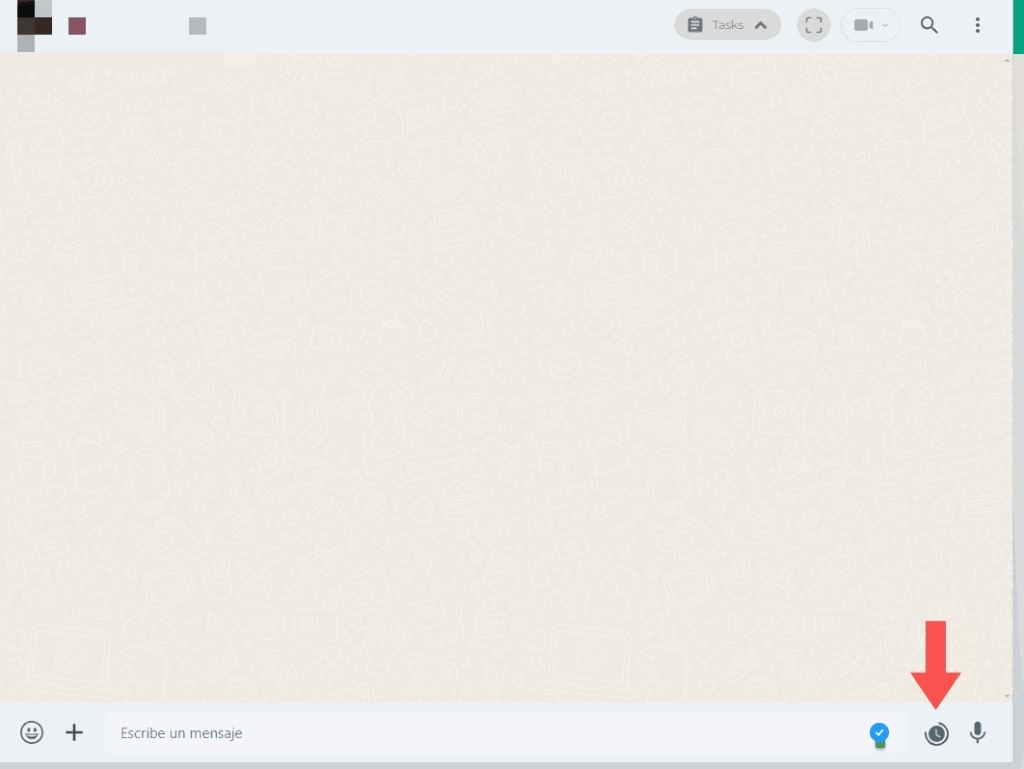 Chat de WhatsApp Web con flecha que señala el ícono de reloj de Blueticks junto al cuadro de texto para programar mensajes.