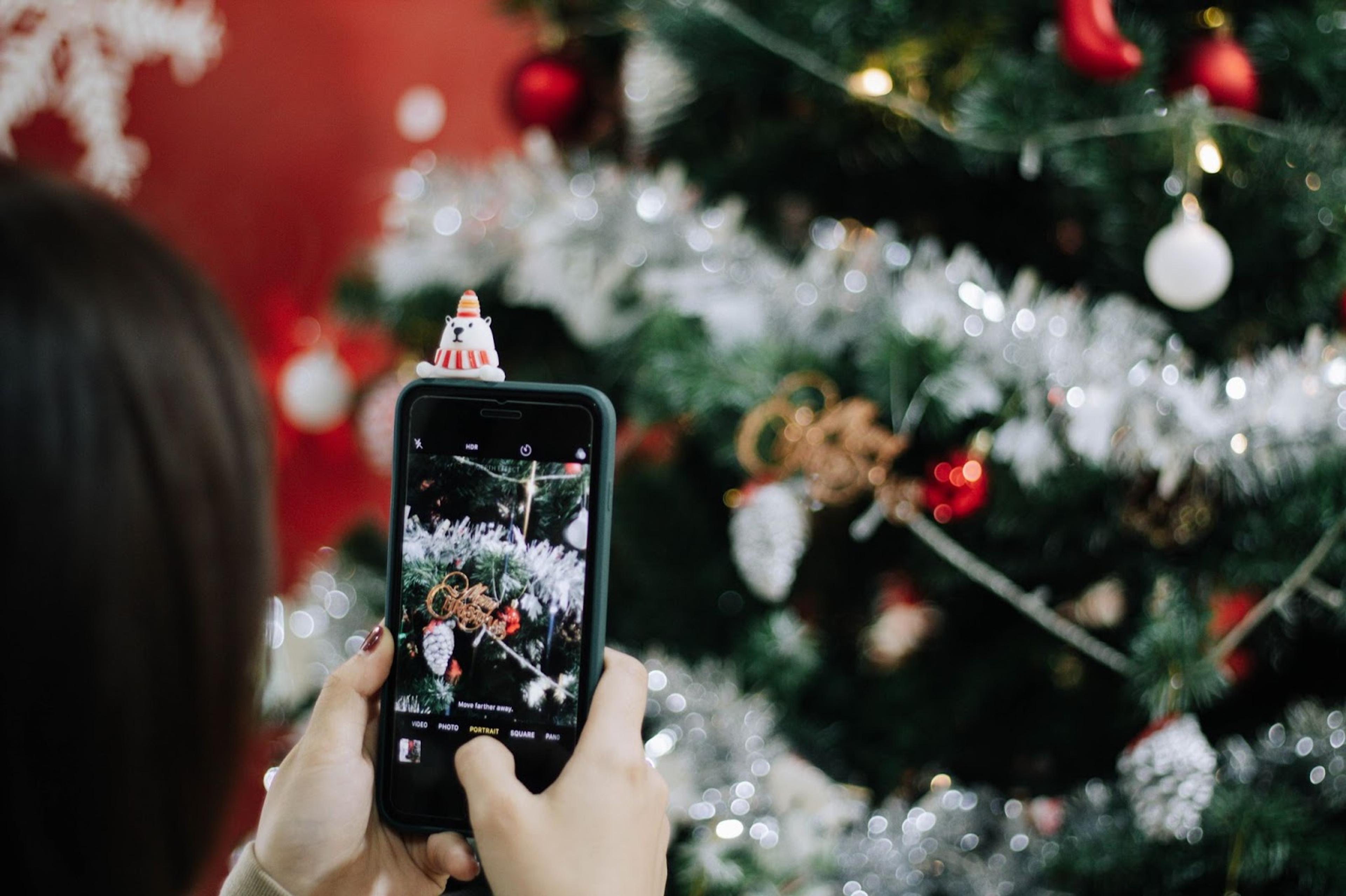 celular tomando una fotografía de un arbol de navidad