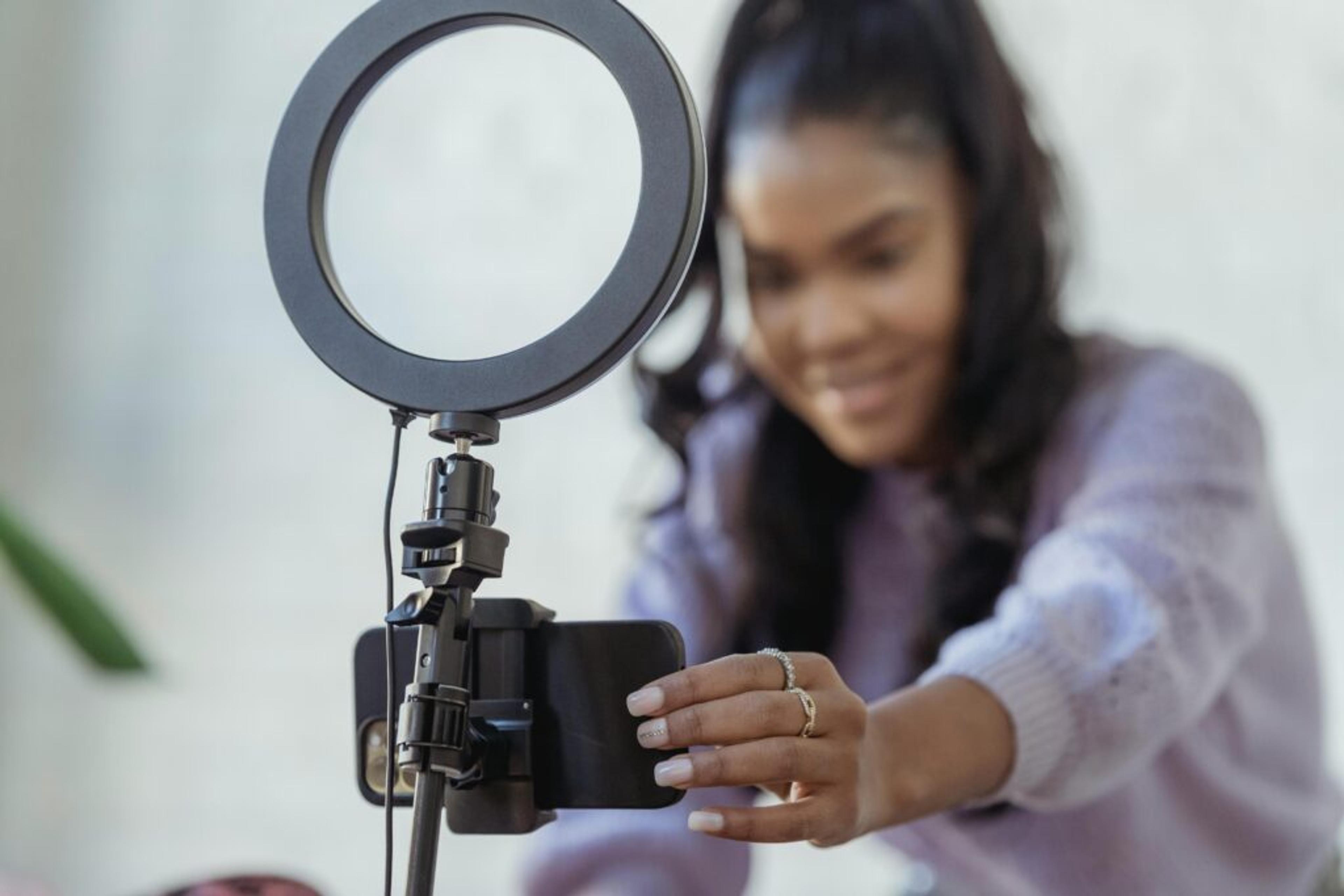 mujer con teléfono inteligente grabando video como medio para prospectar clientes