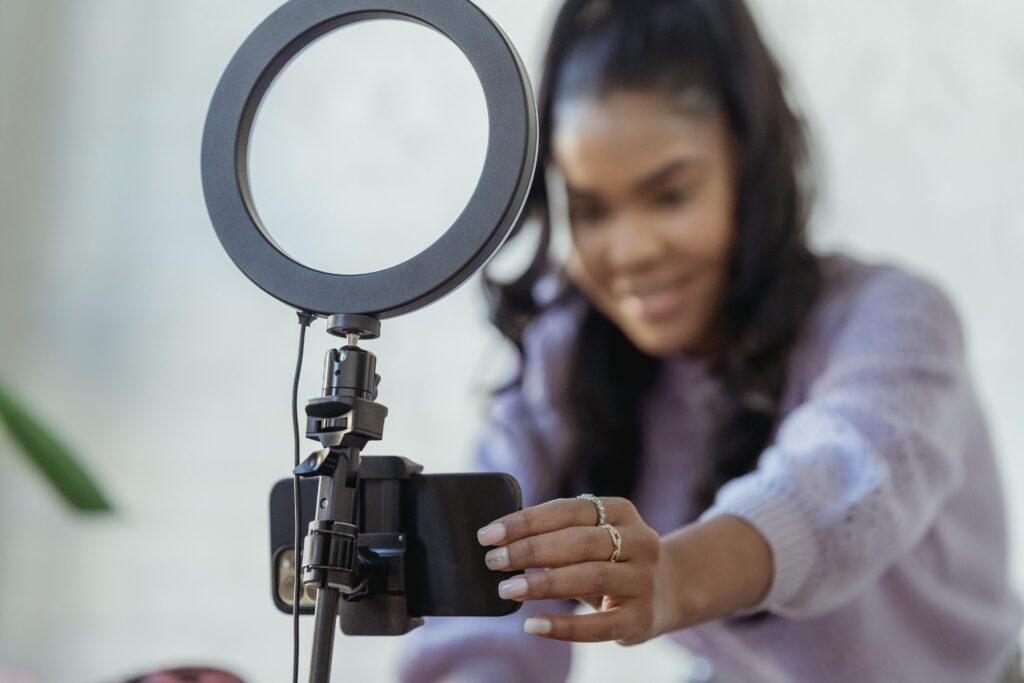 mujer con teléfono inteligente grabando video como medio para prospectar clientes