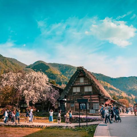 Casa de tejado de paja gasshō-zukuri en Shirakawa-go, con montañas detrás