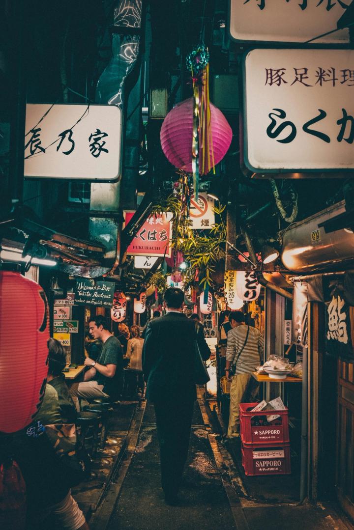 Un callejón de izakayas de Tokio de noche, con faroles y carteles encendidos
