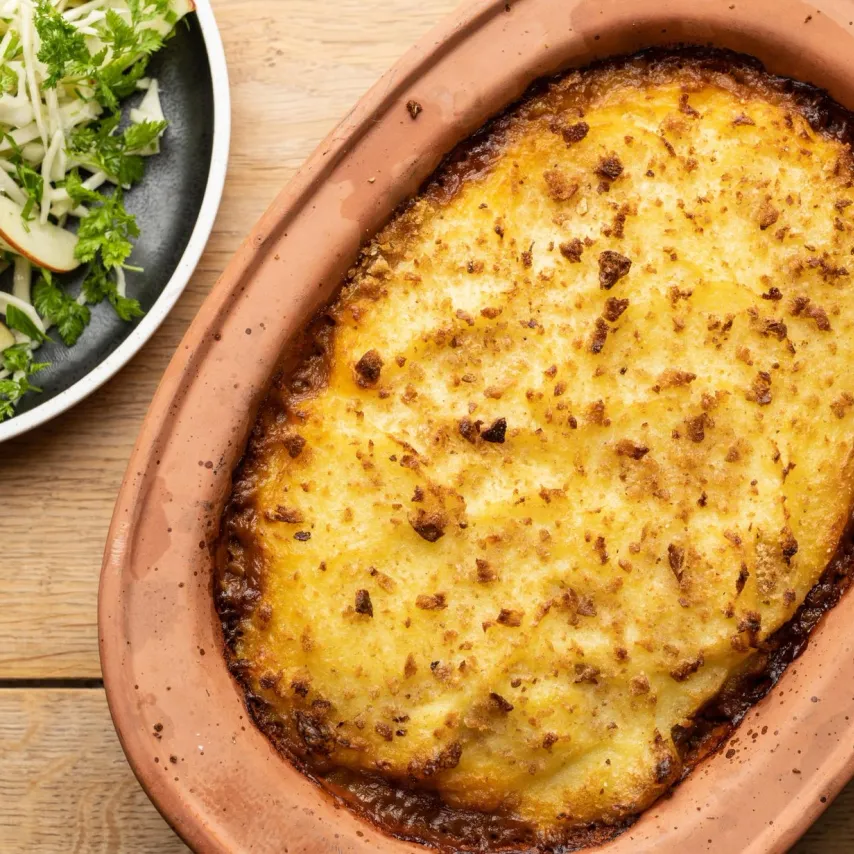Gratin med brune linser, gule ærter, kartofler og salvie med råkost af vinterkål