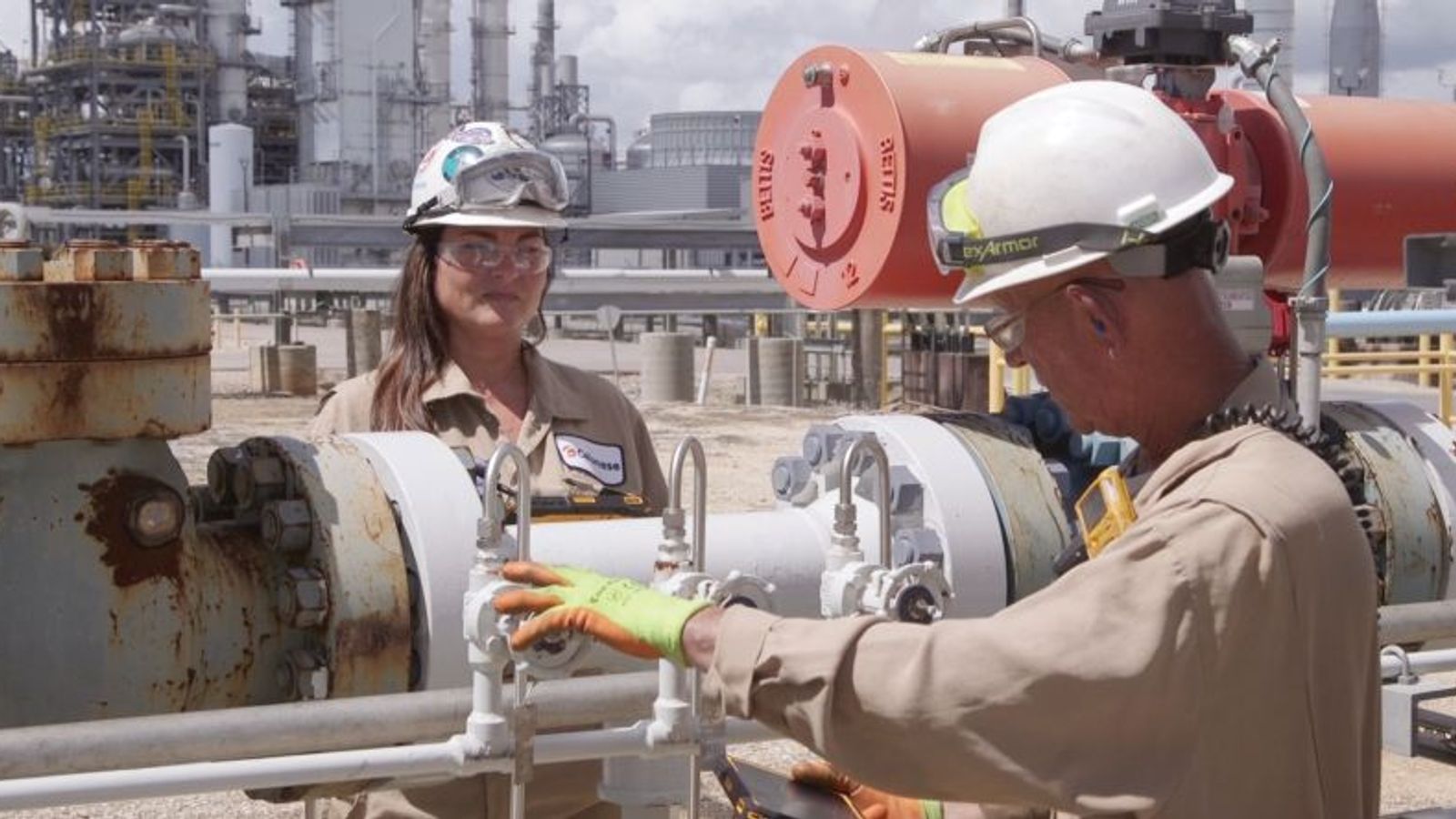Manufacturing employees wearing safety gear inside an industrial facility