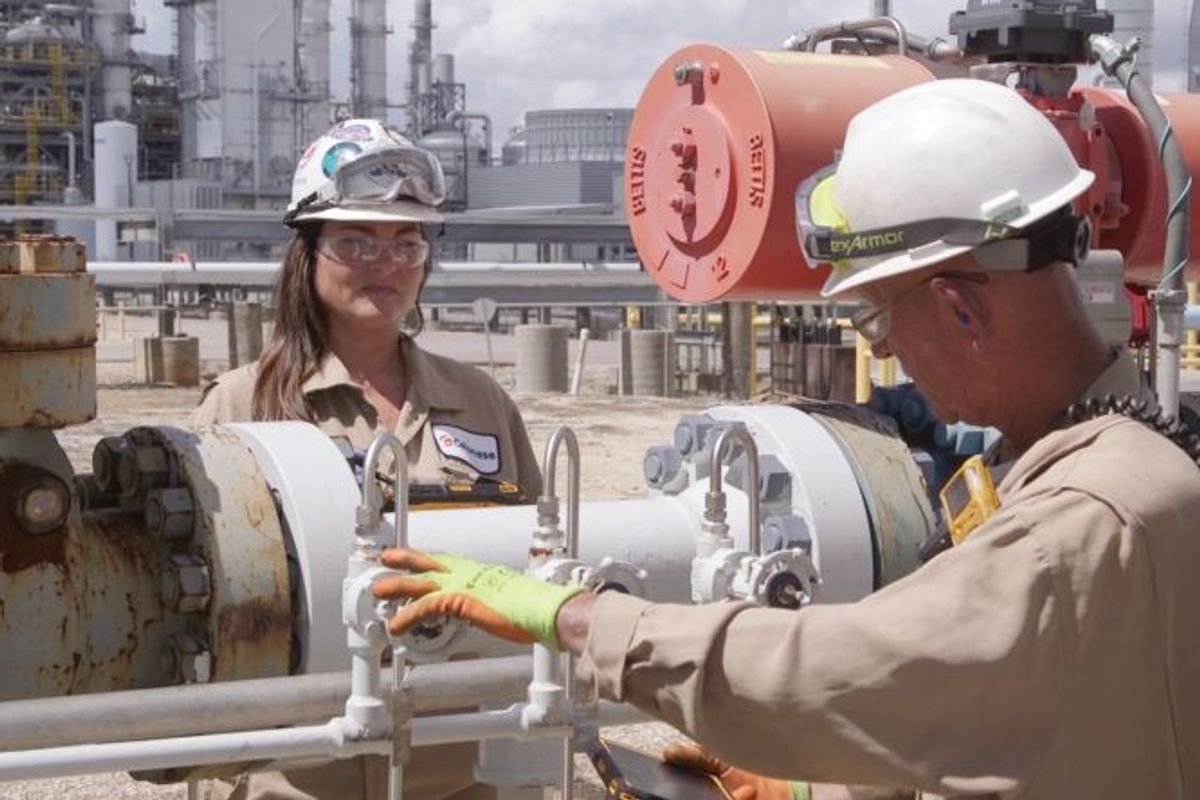 Manufacturing employees wearing safety gear inside an industrial facility