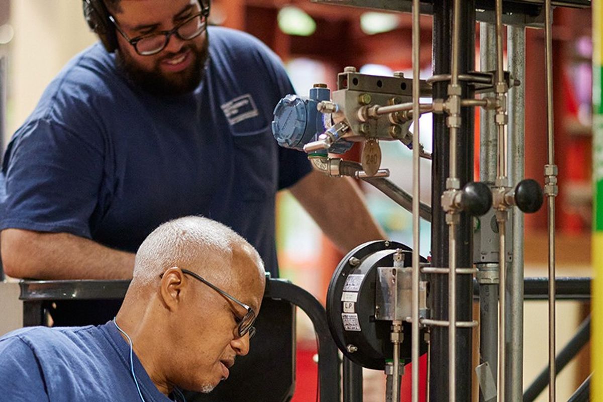 Industrial maintenance workers inspecting equipment inside a facility