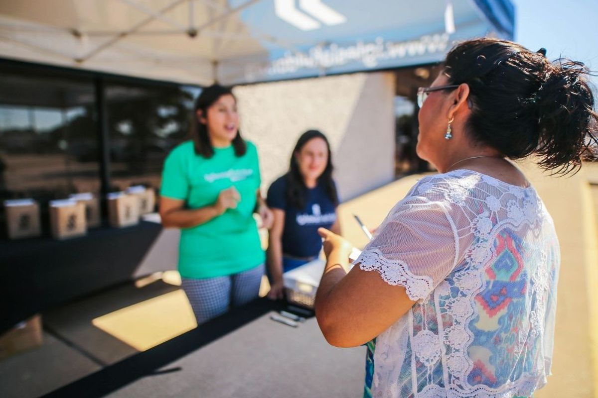 Healthcare representative speaking with a community member outdoors