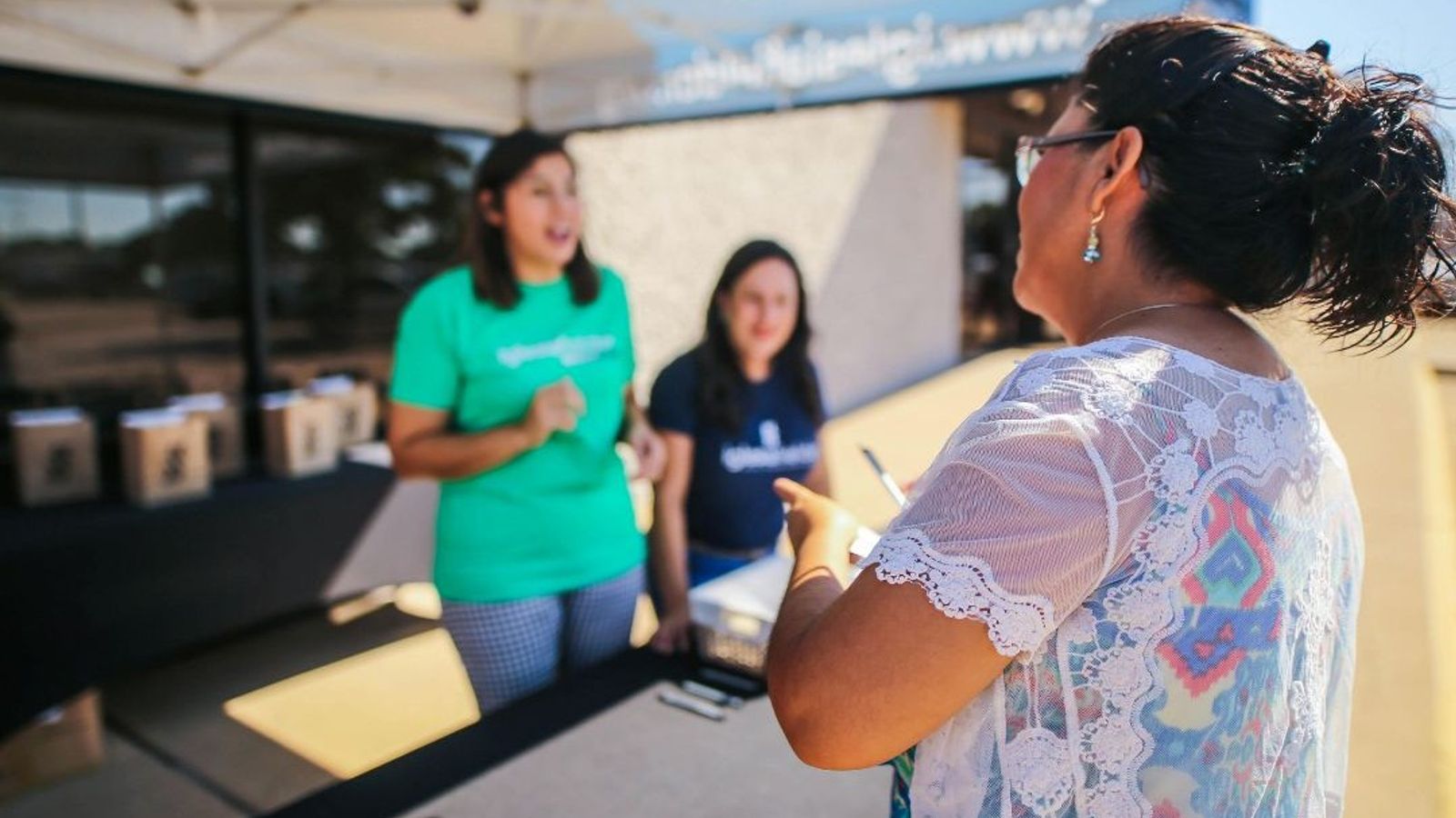 Healthcare representative speaking with a community member outdoors