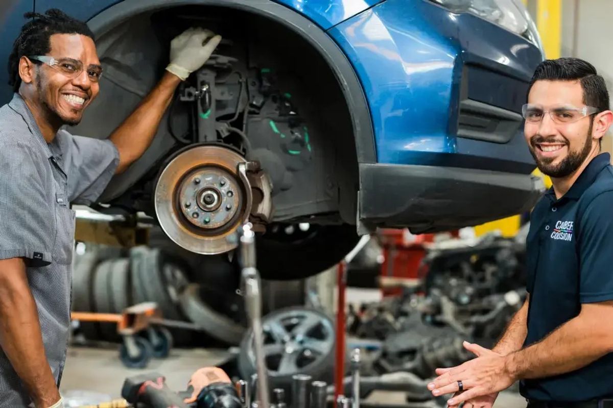 Two automotive technicians inspecting a vehicle together