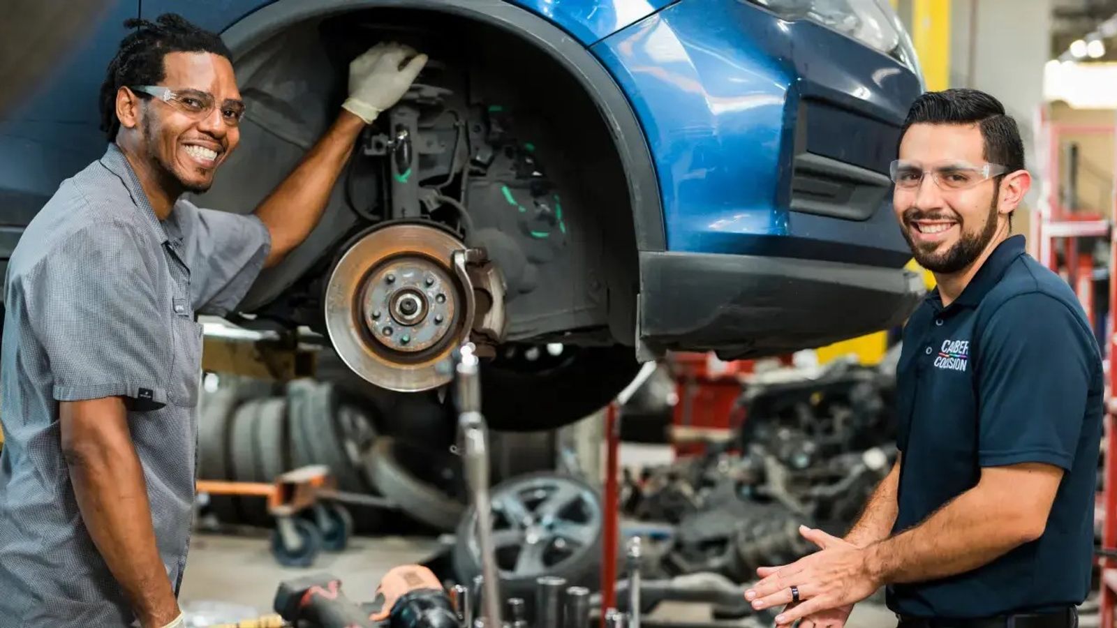 Two automotive technicians inspecting a vehicle together