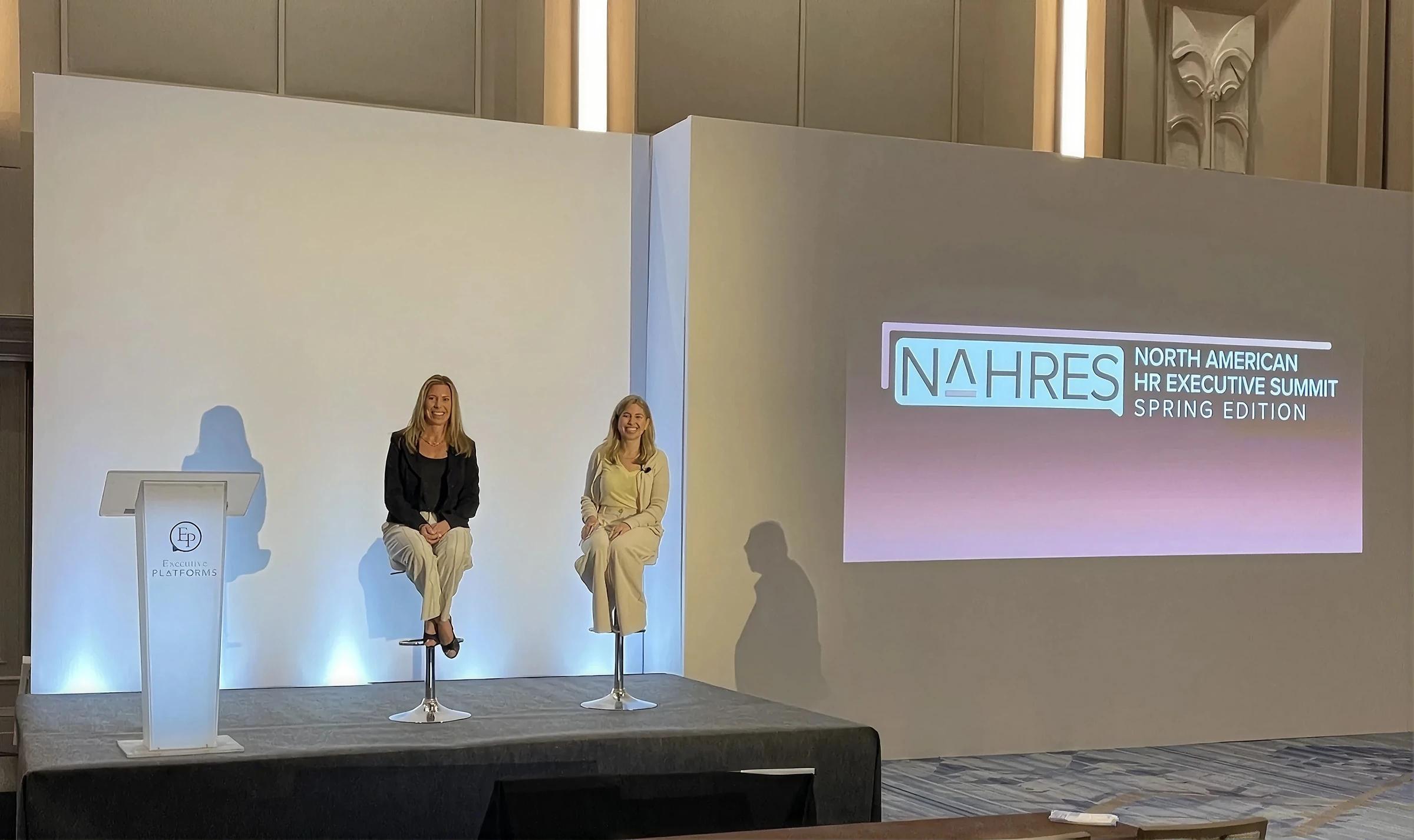 Two speakers seated on stage at the NAHRES Spring Edition
