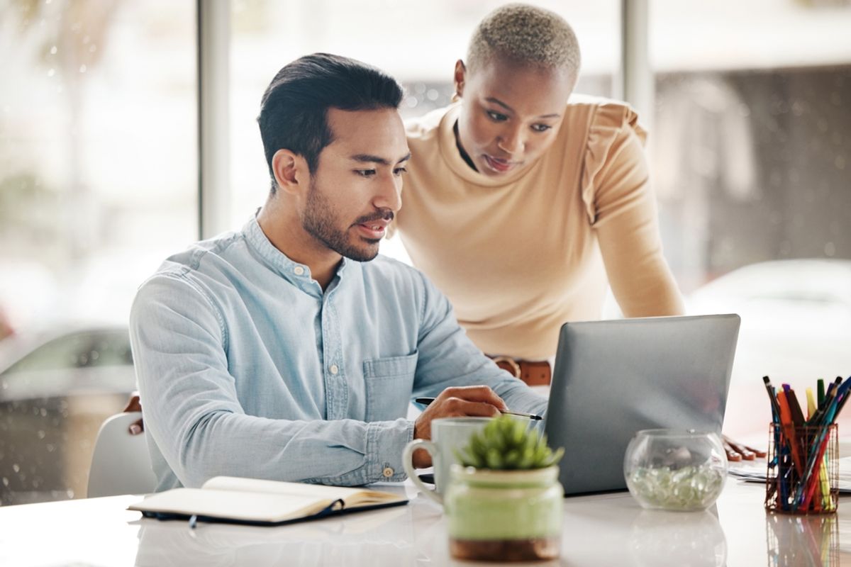 Two colleagues reading pay information together on a laptop