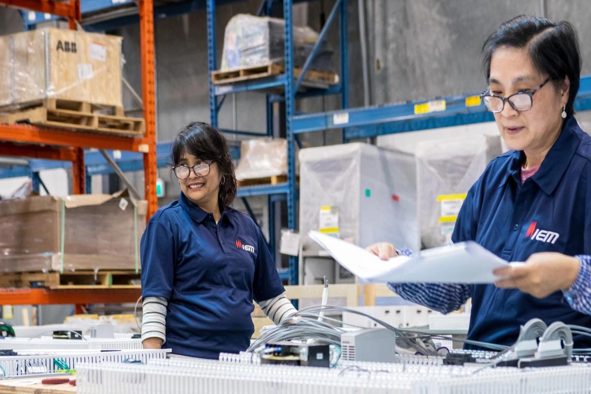 Two manufacturing employees working beside production equipment