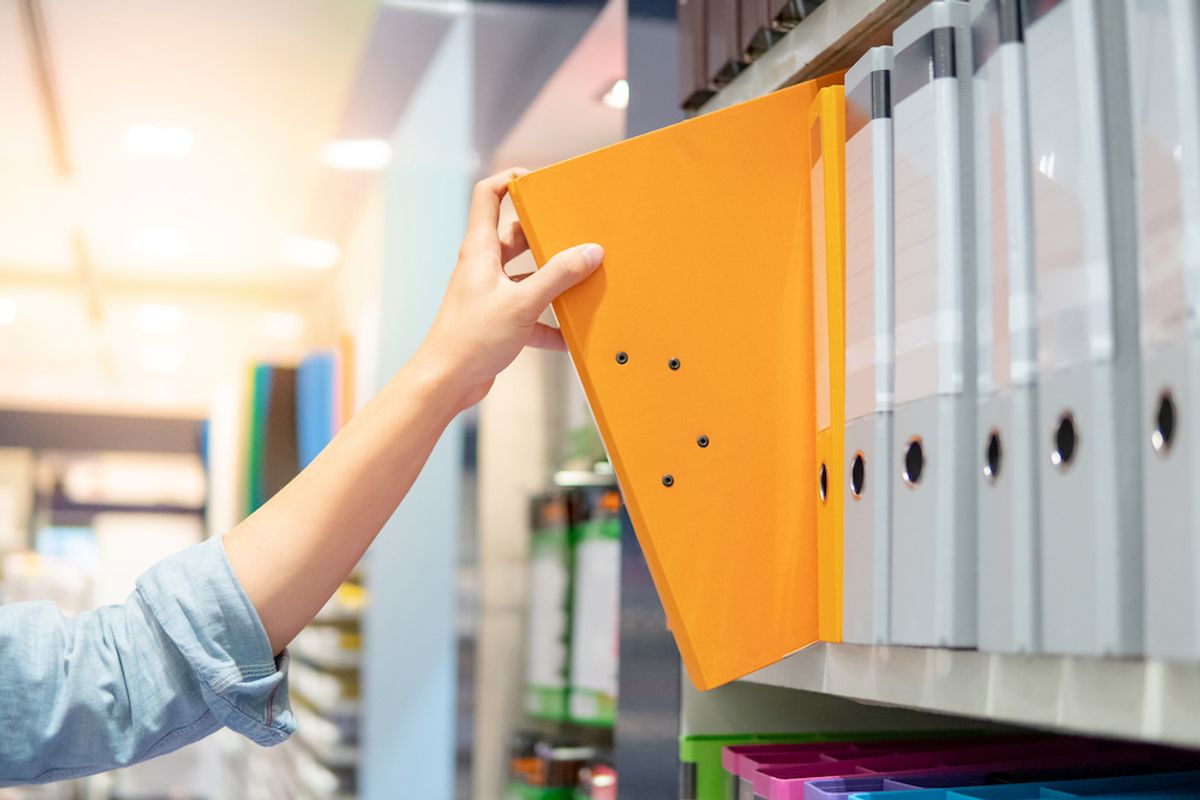 Hand placing bookstore supplies on shelf