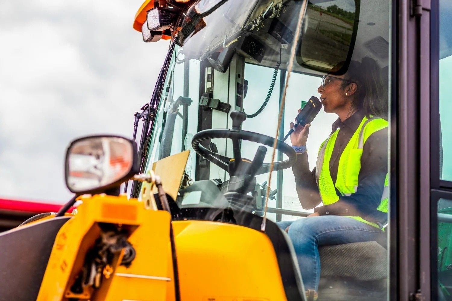 Equipment operator driving heavy machinery through an auction yard