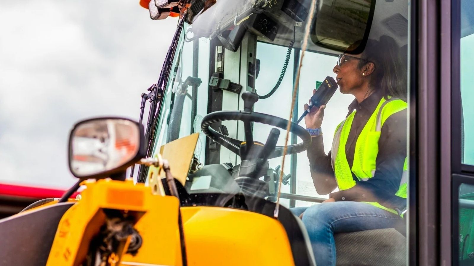 Equipment operator driving heavy machinery through an auction yard
