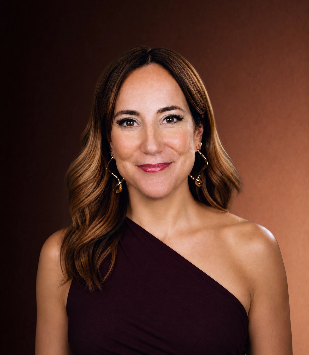 Portrait de Coralie Boscarato sur un fond de studio aux tons chauds.