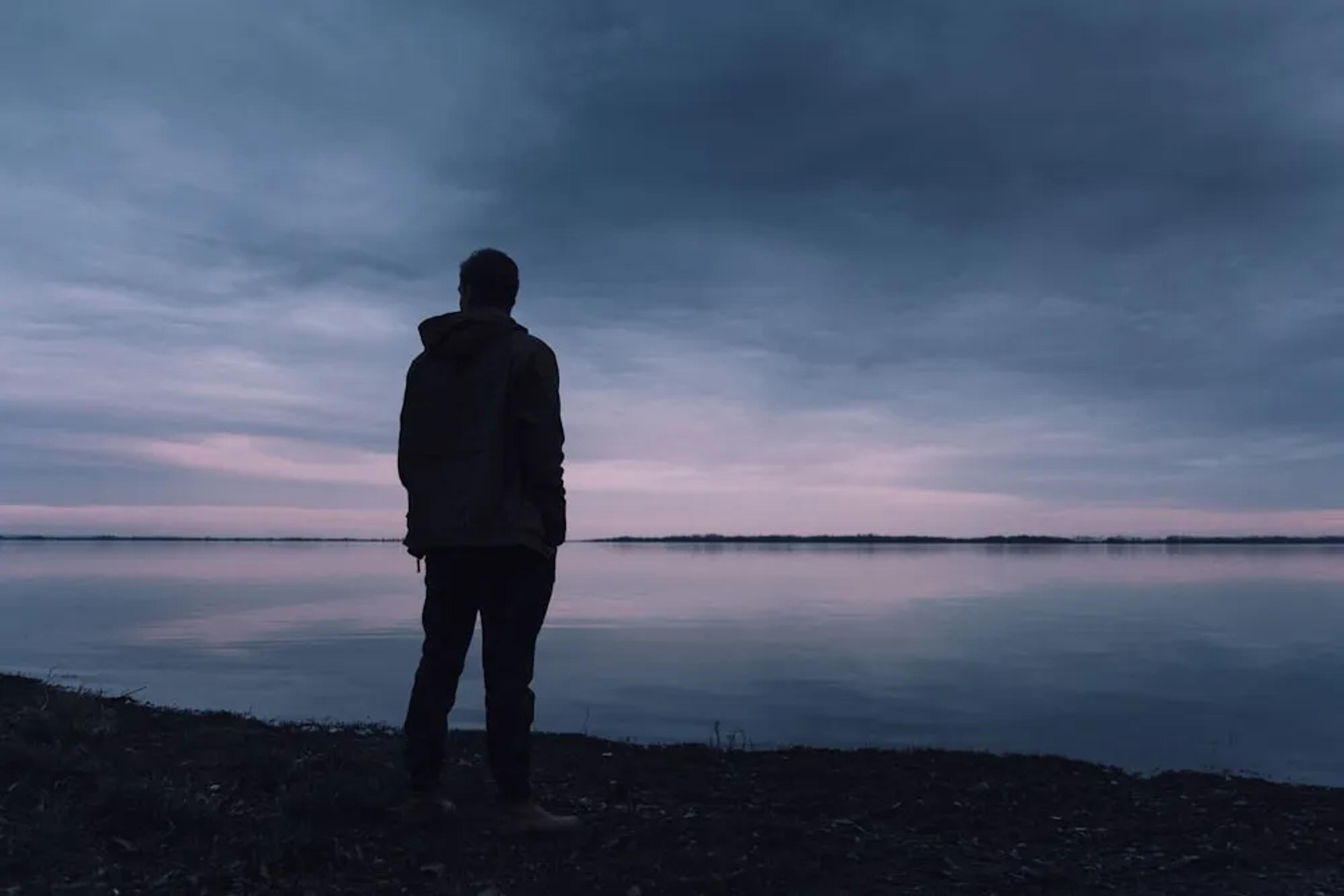 man alone standin by a body of water