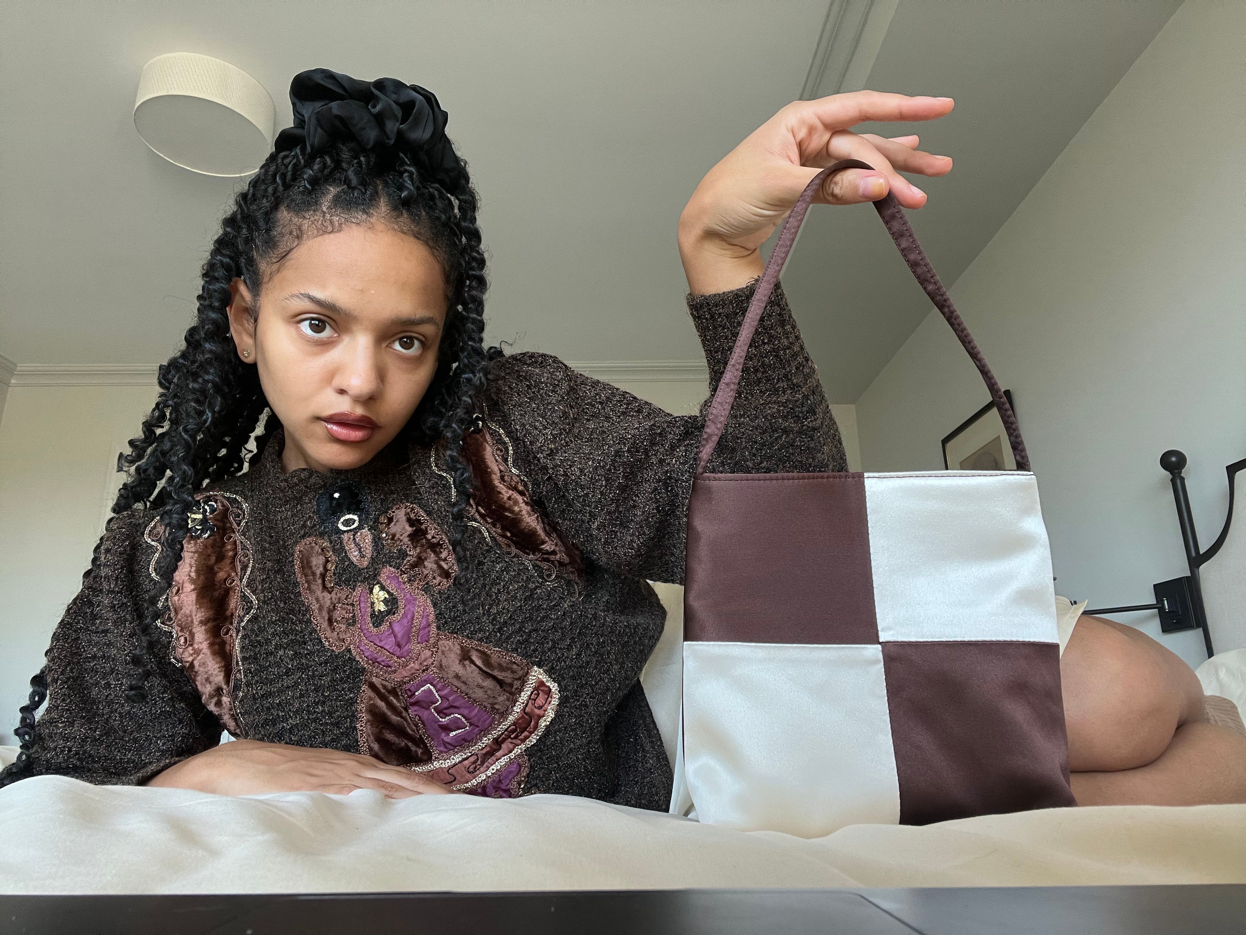 Actor Djouliet Amara poses with her chequered Hai Vera Bag in Brown & Ivory