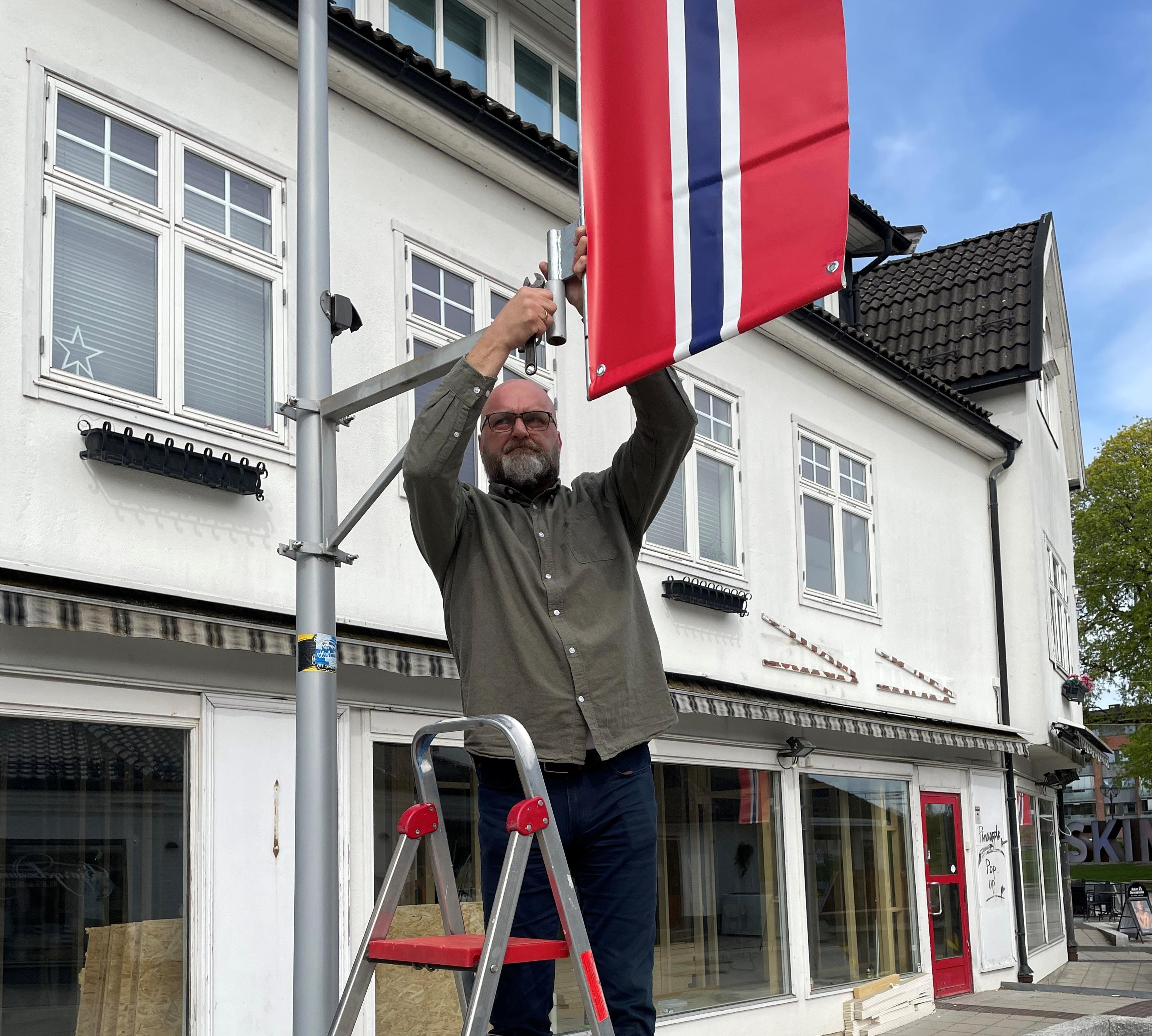 Mann henger opp et flagg