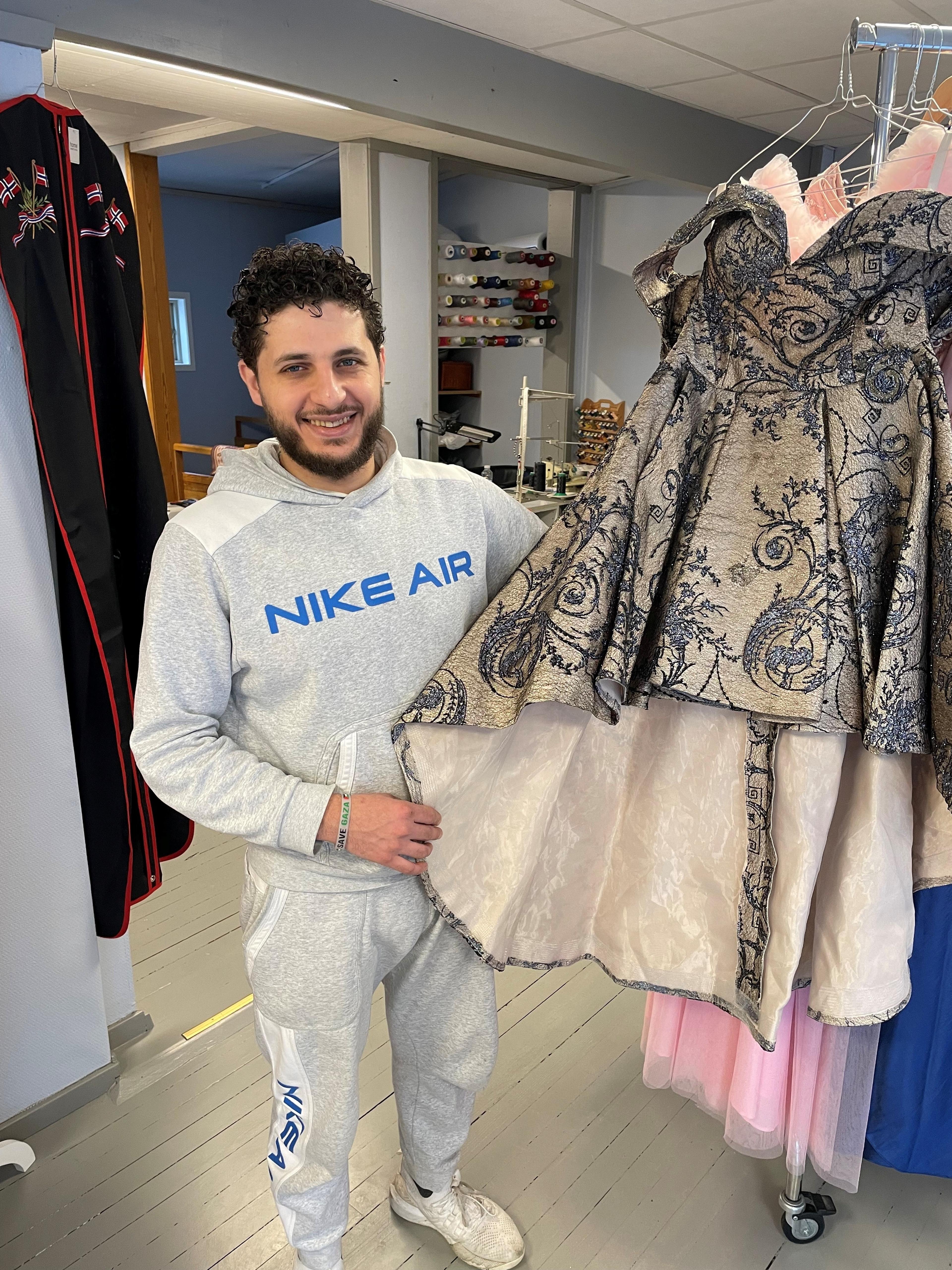 Mann som viser frem en kjole