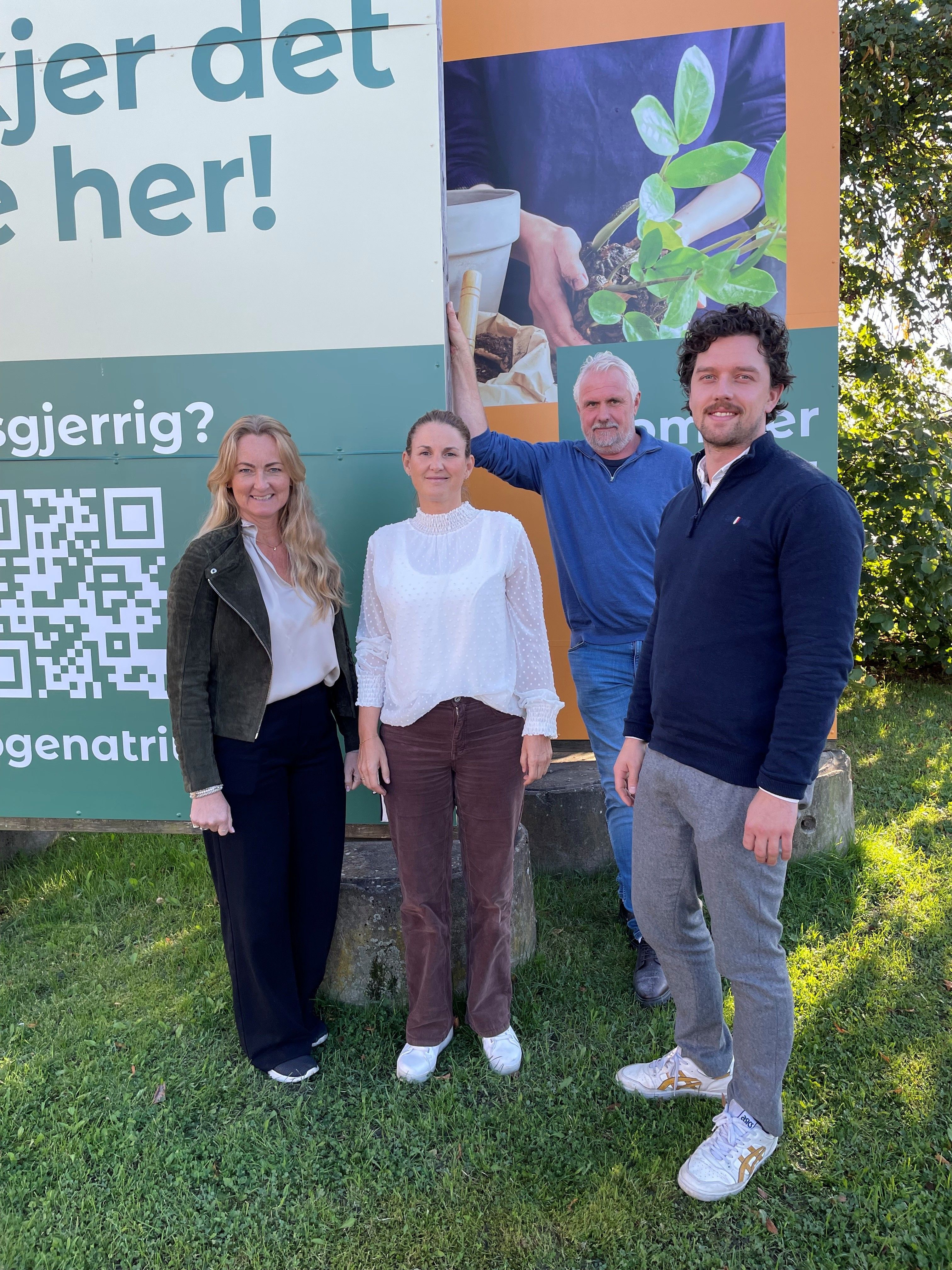 to damer og to menn på en grønn plen
