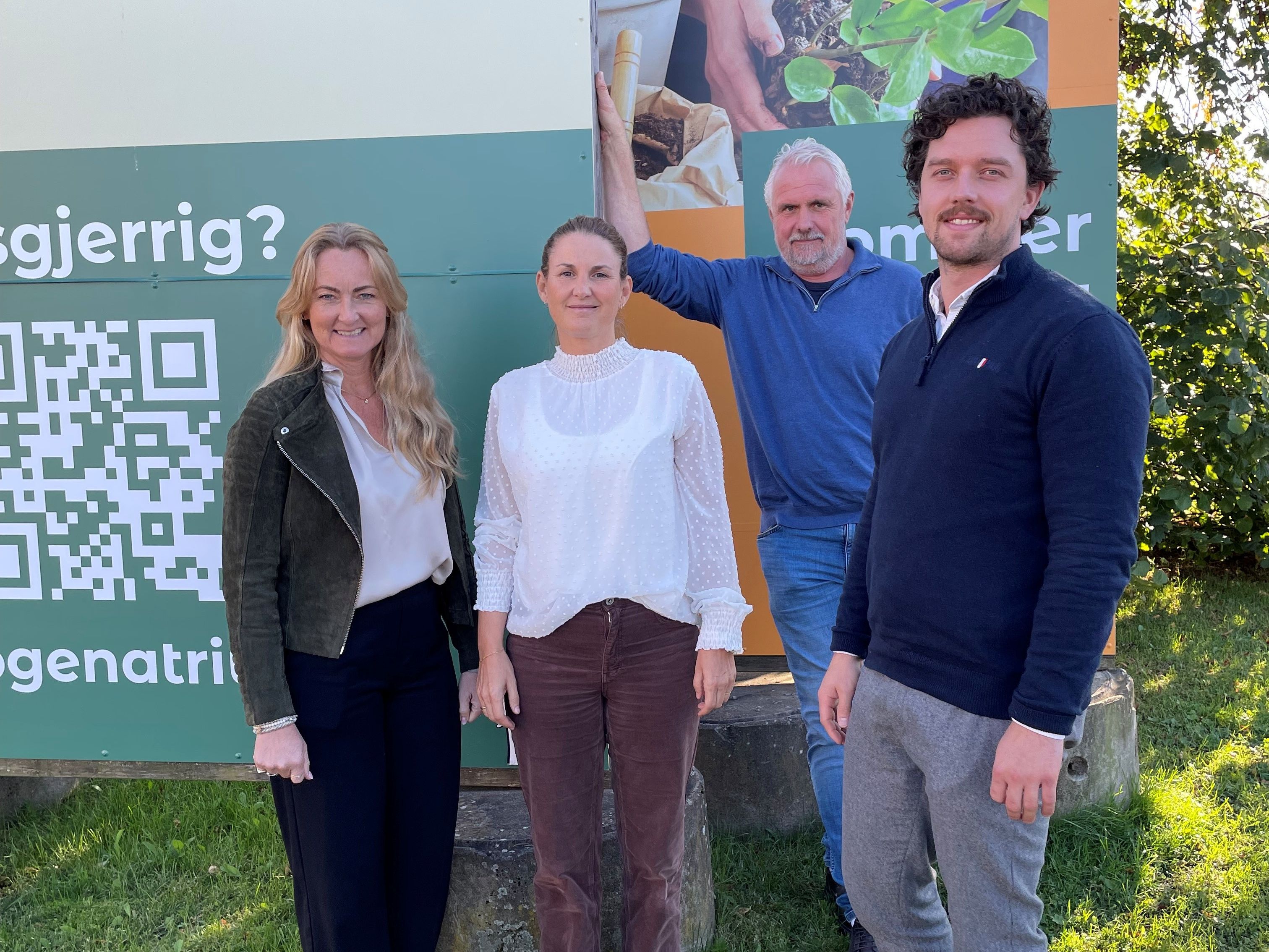 to damer og to menn på en grønn plen