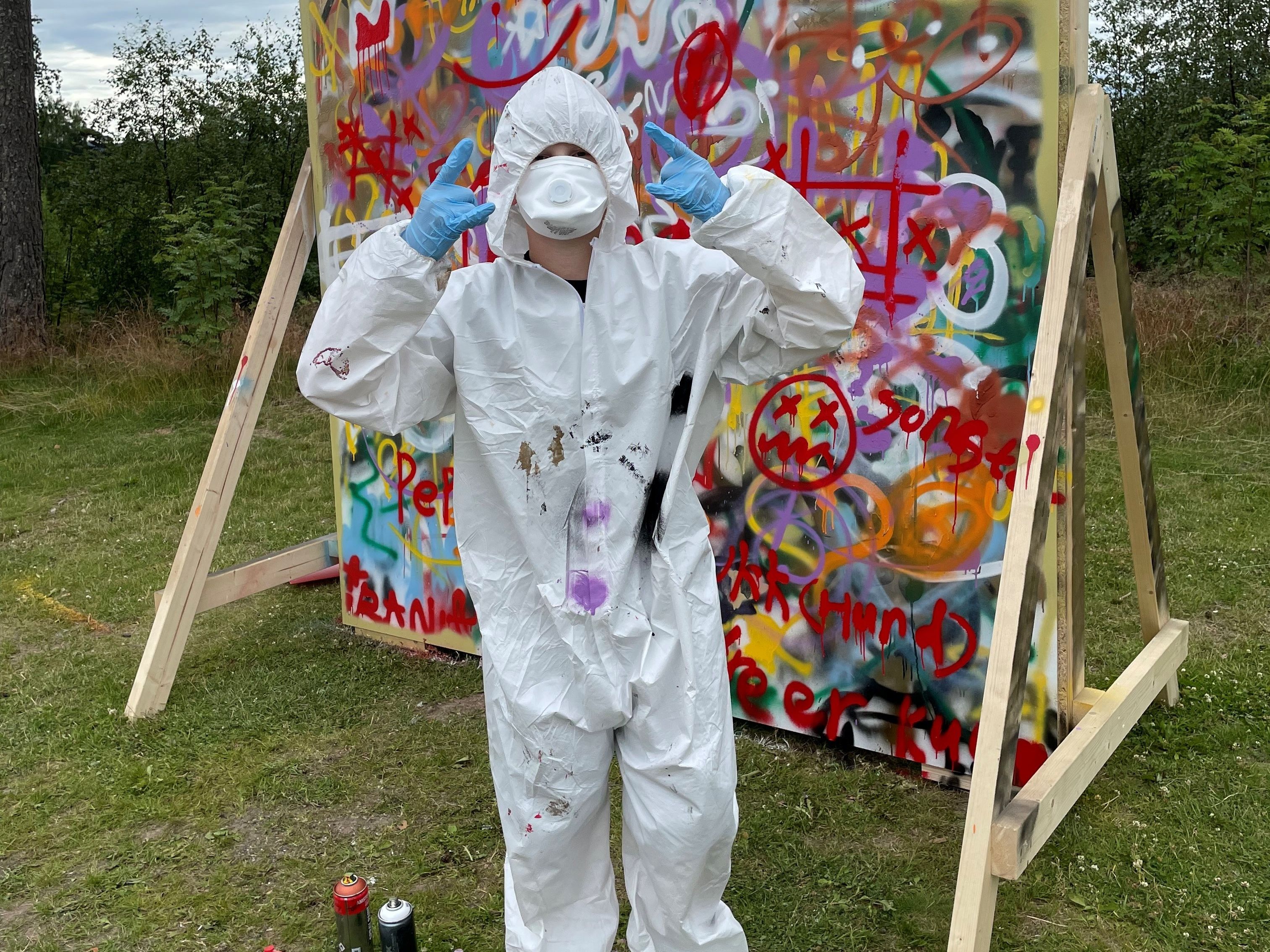 Ungt menneske foran grafitti vegg