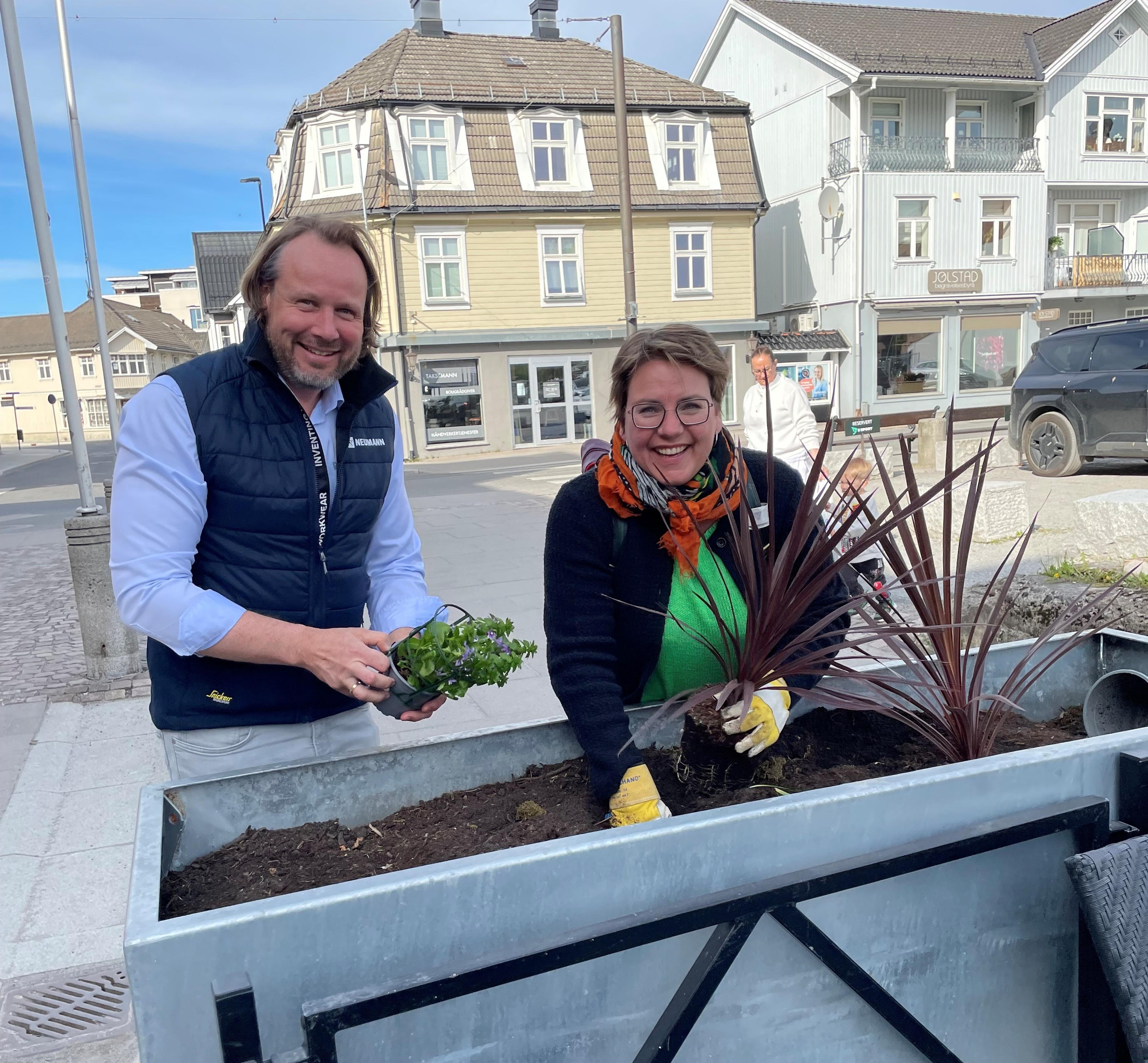 Mann og dame som planter blomster