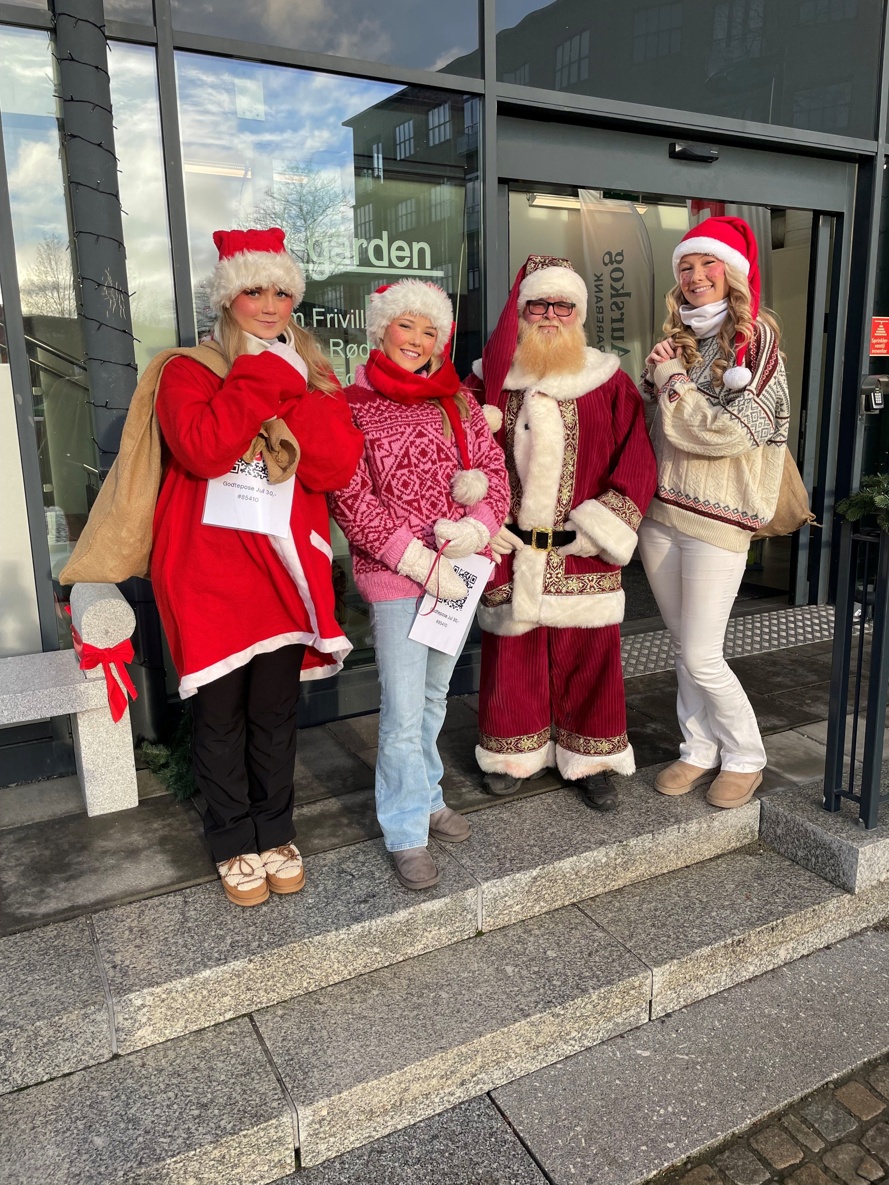 Julenissen med tre jenter som er hjelpere