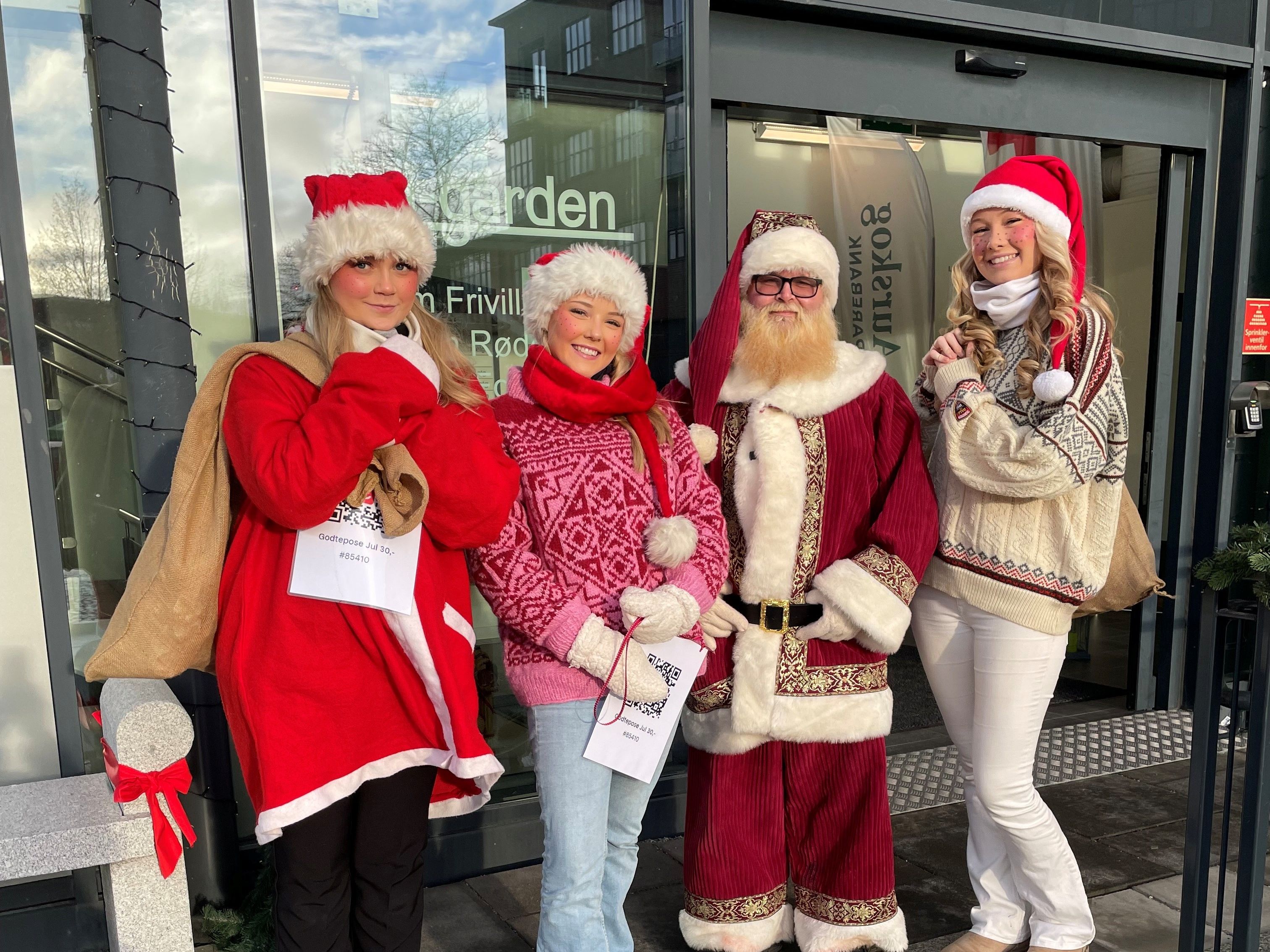 Julenissen med tre jenter som er hjelpere