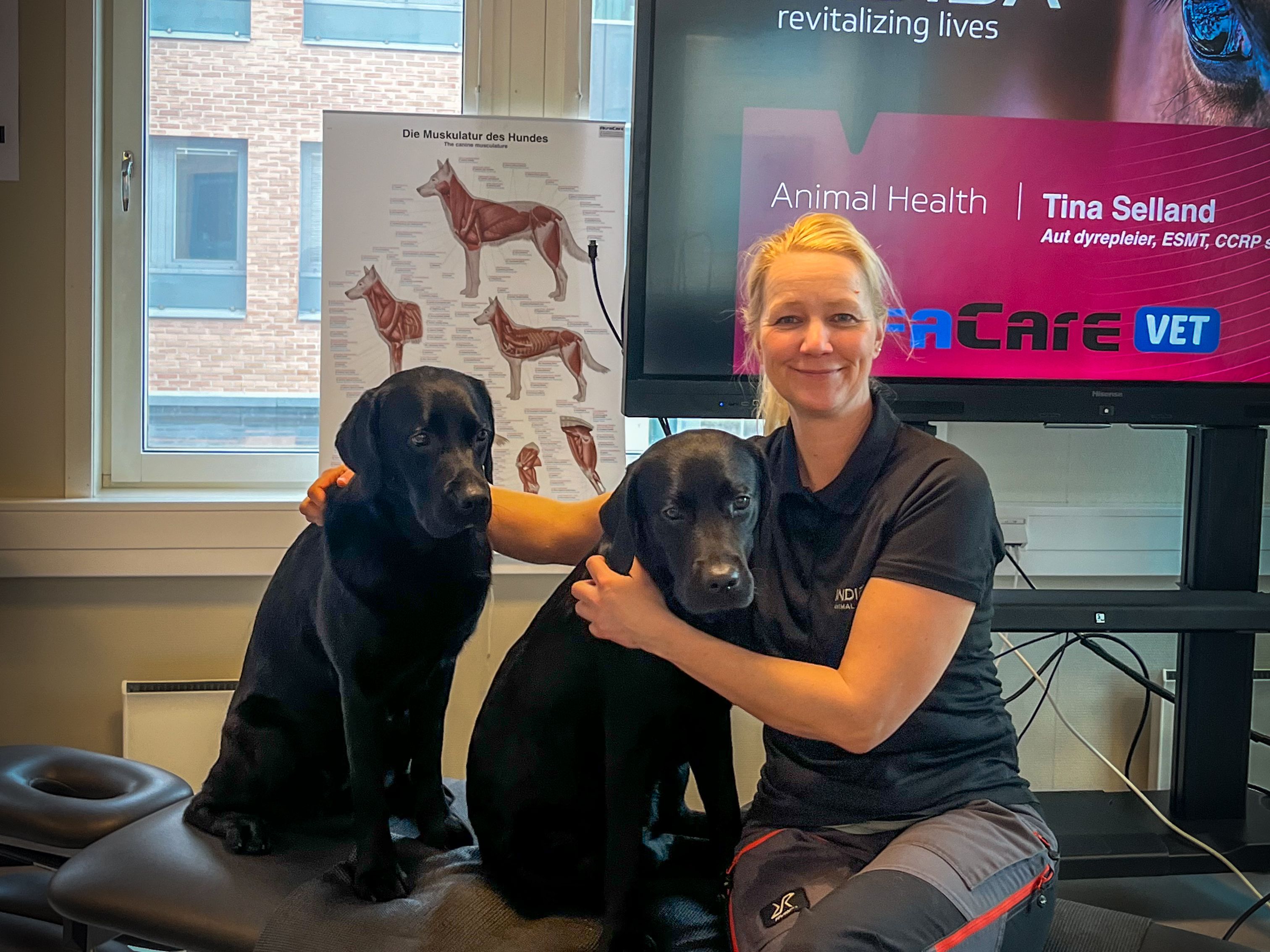 En dame med to svarte hunder