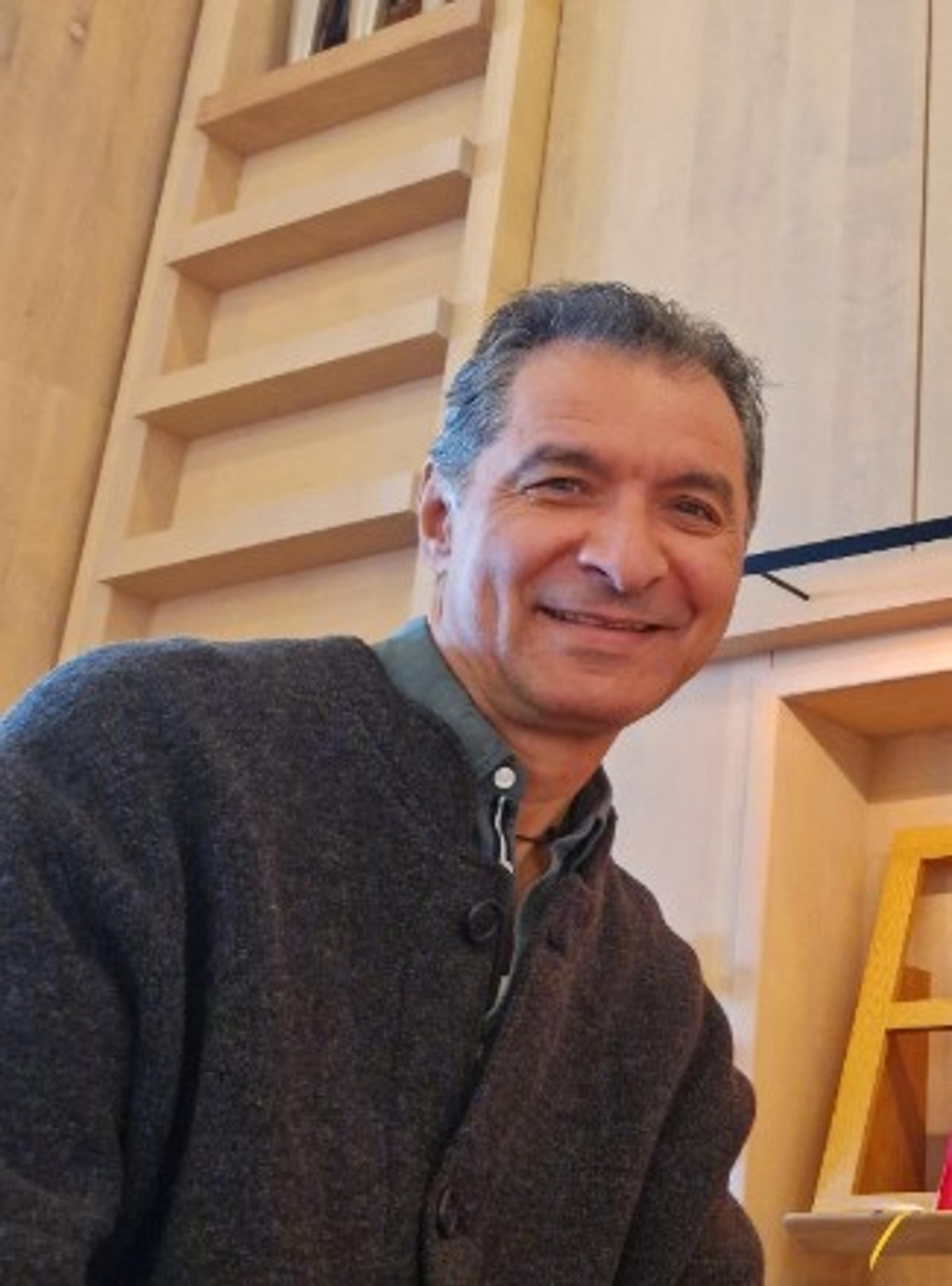 En blid mann i grå genser