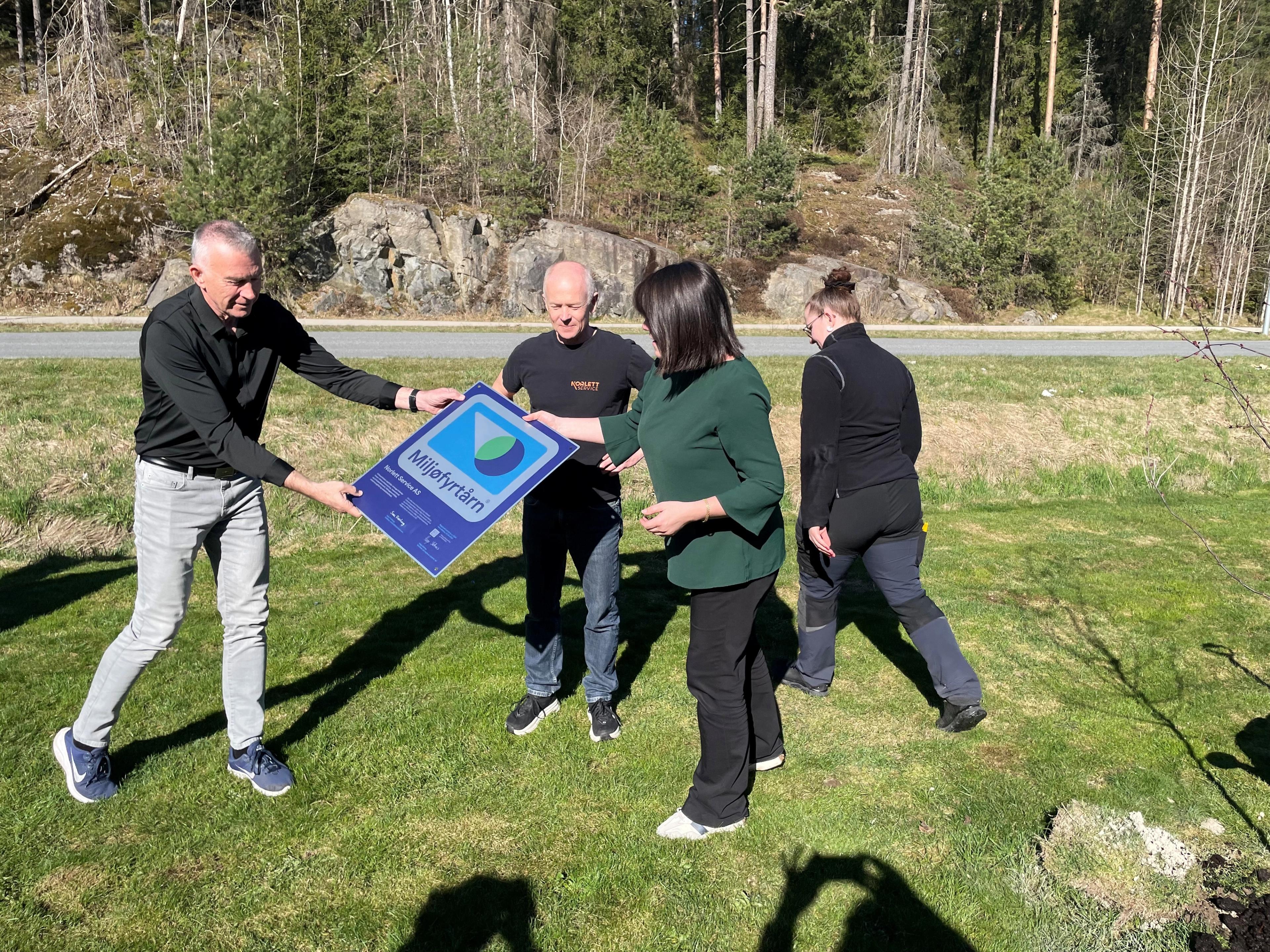 tre personer med miljøfyrtårn-plakett 