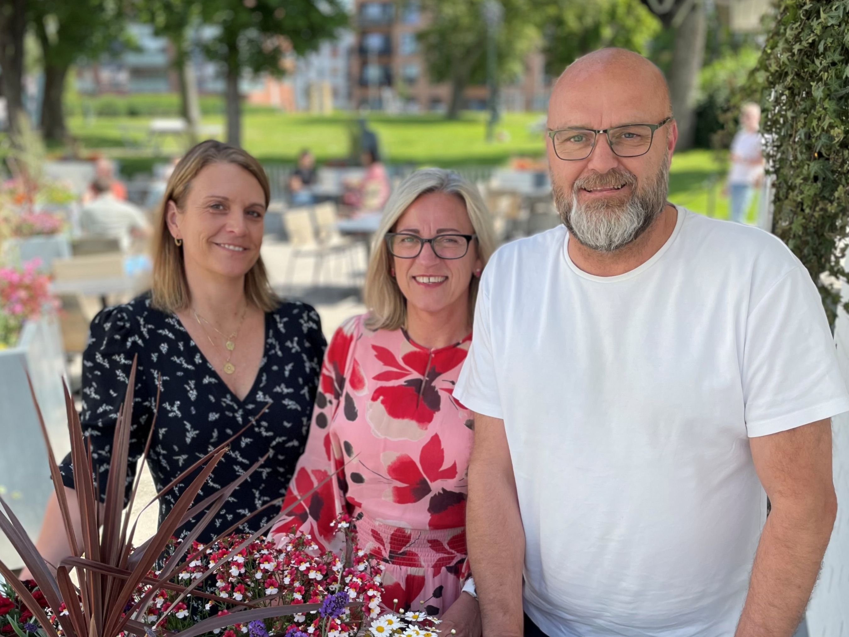 Fine mennesker foran flotte blomsterkasser