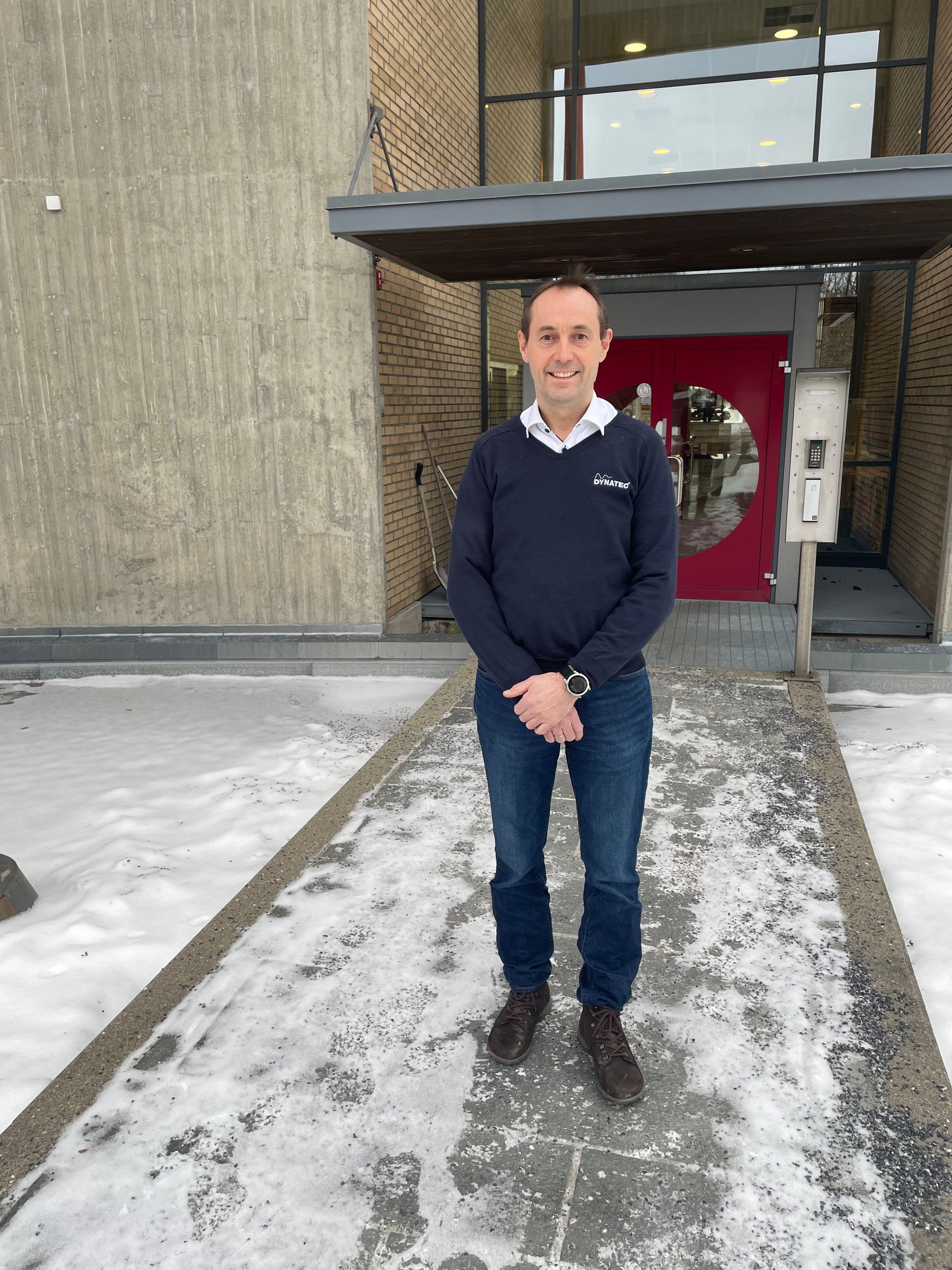 En blid mann utenfor en bygning