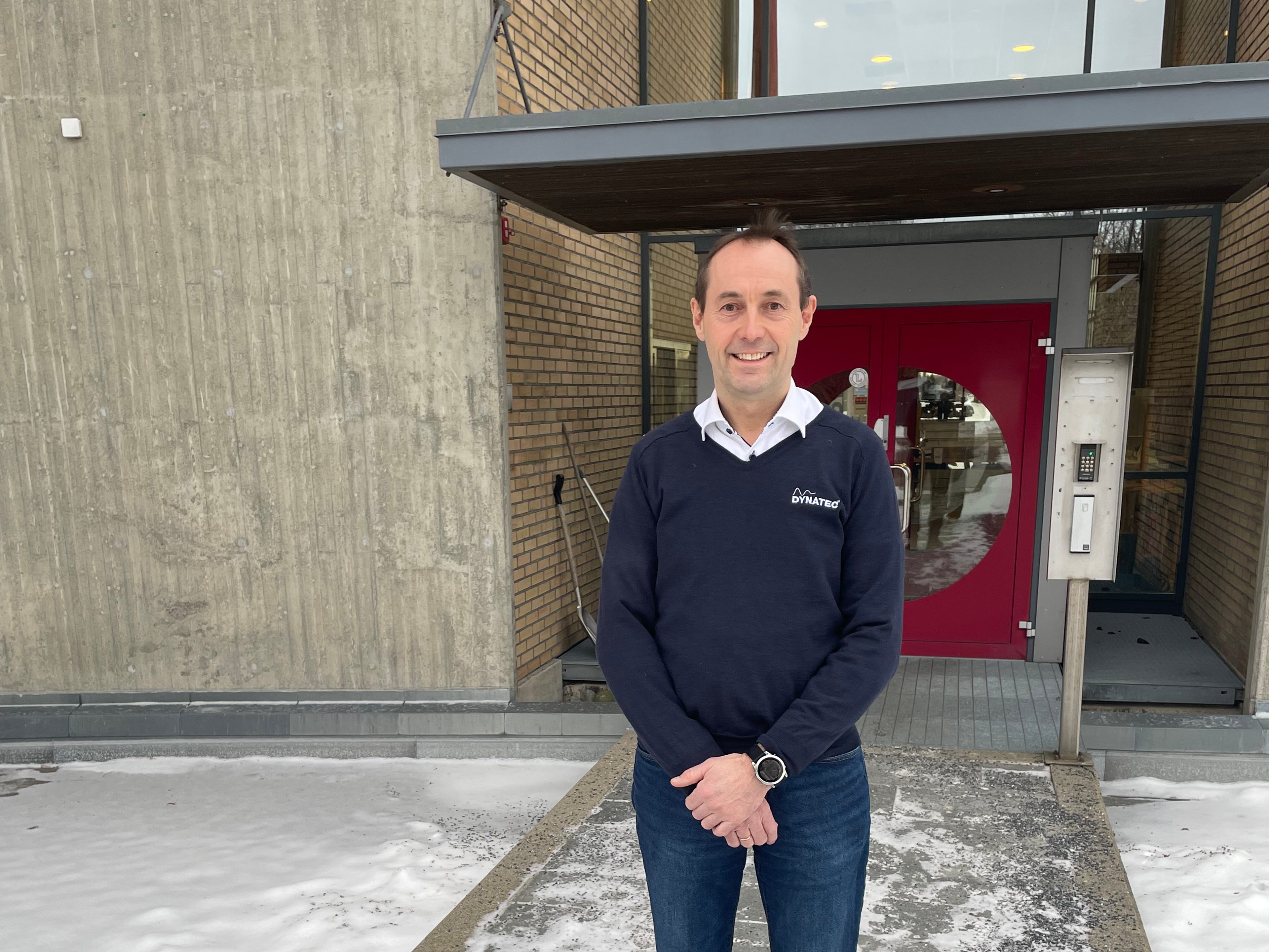 En blid mann utenfor en bygning