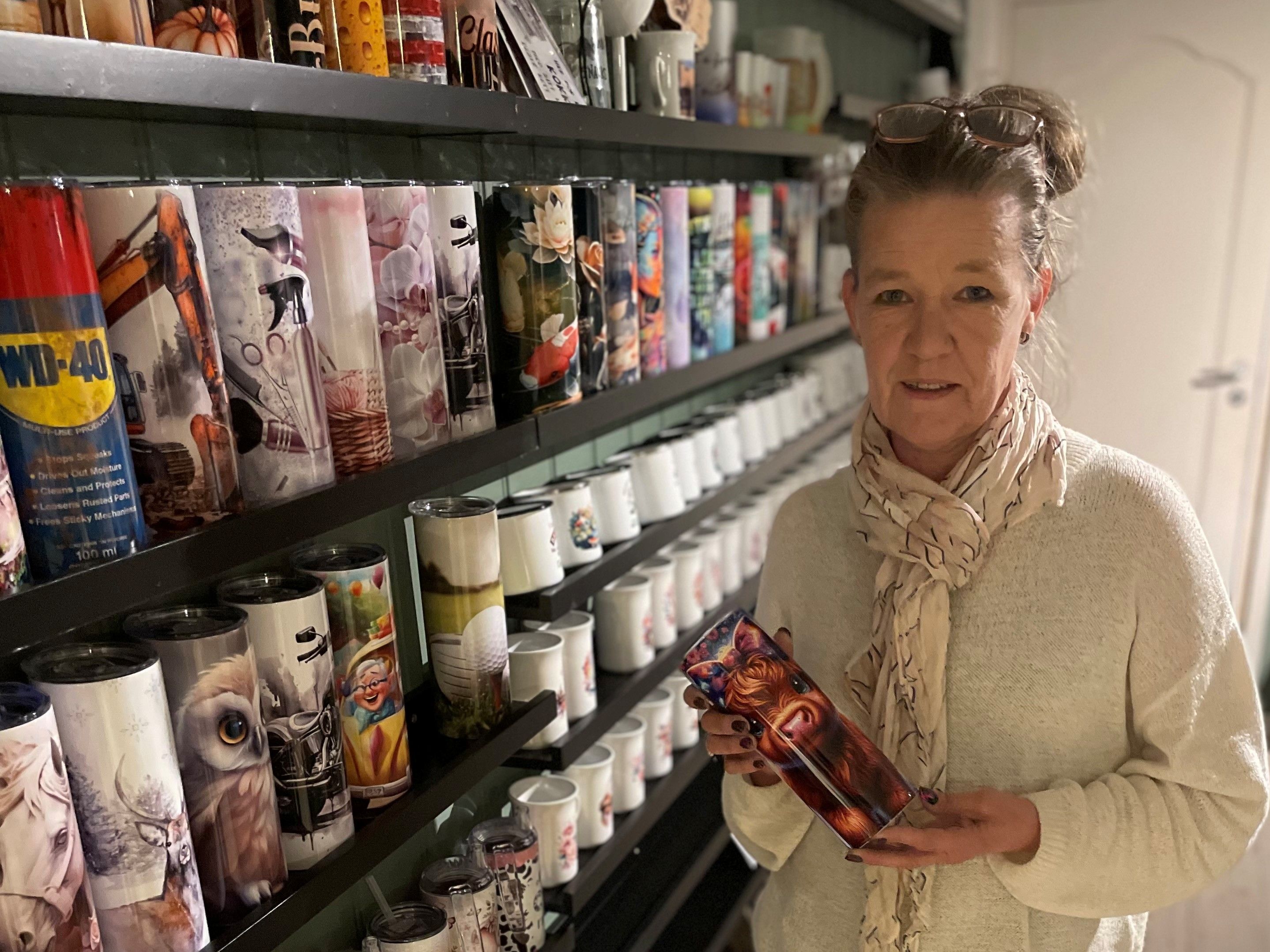 Monica som står foran egenproduserte kopper