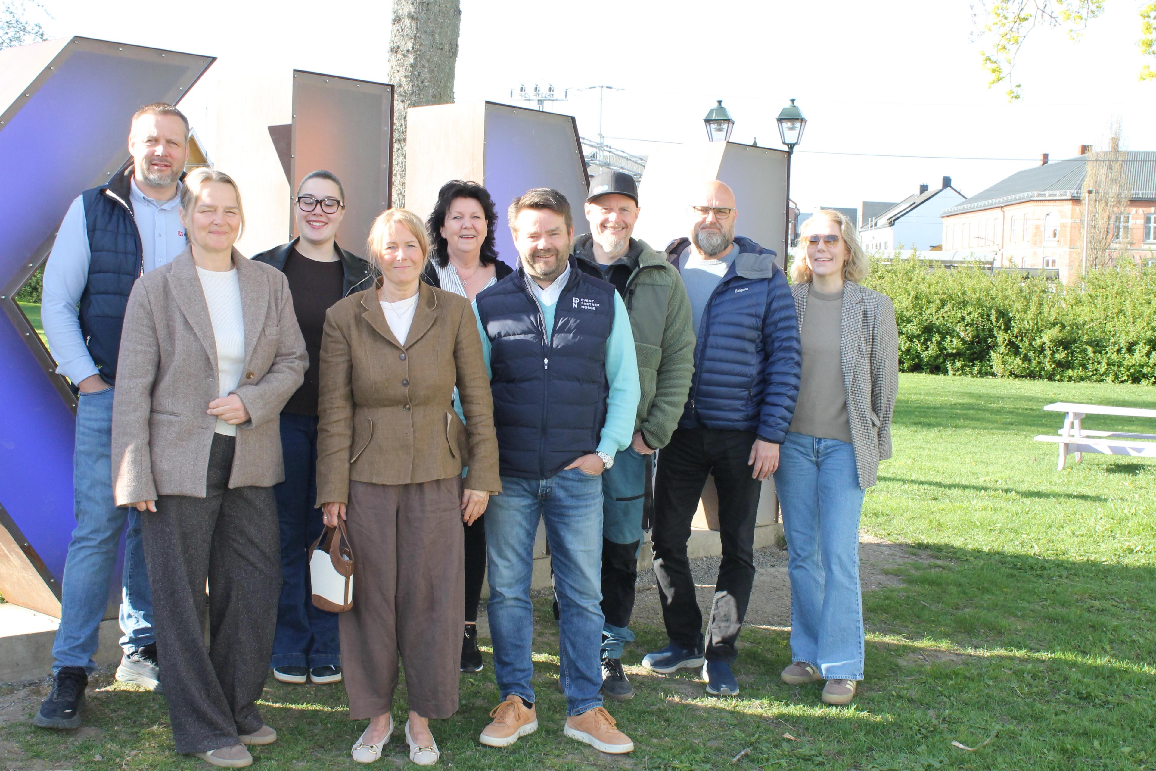 ni mennesker foran askim bokstavene