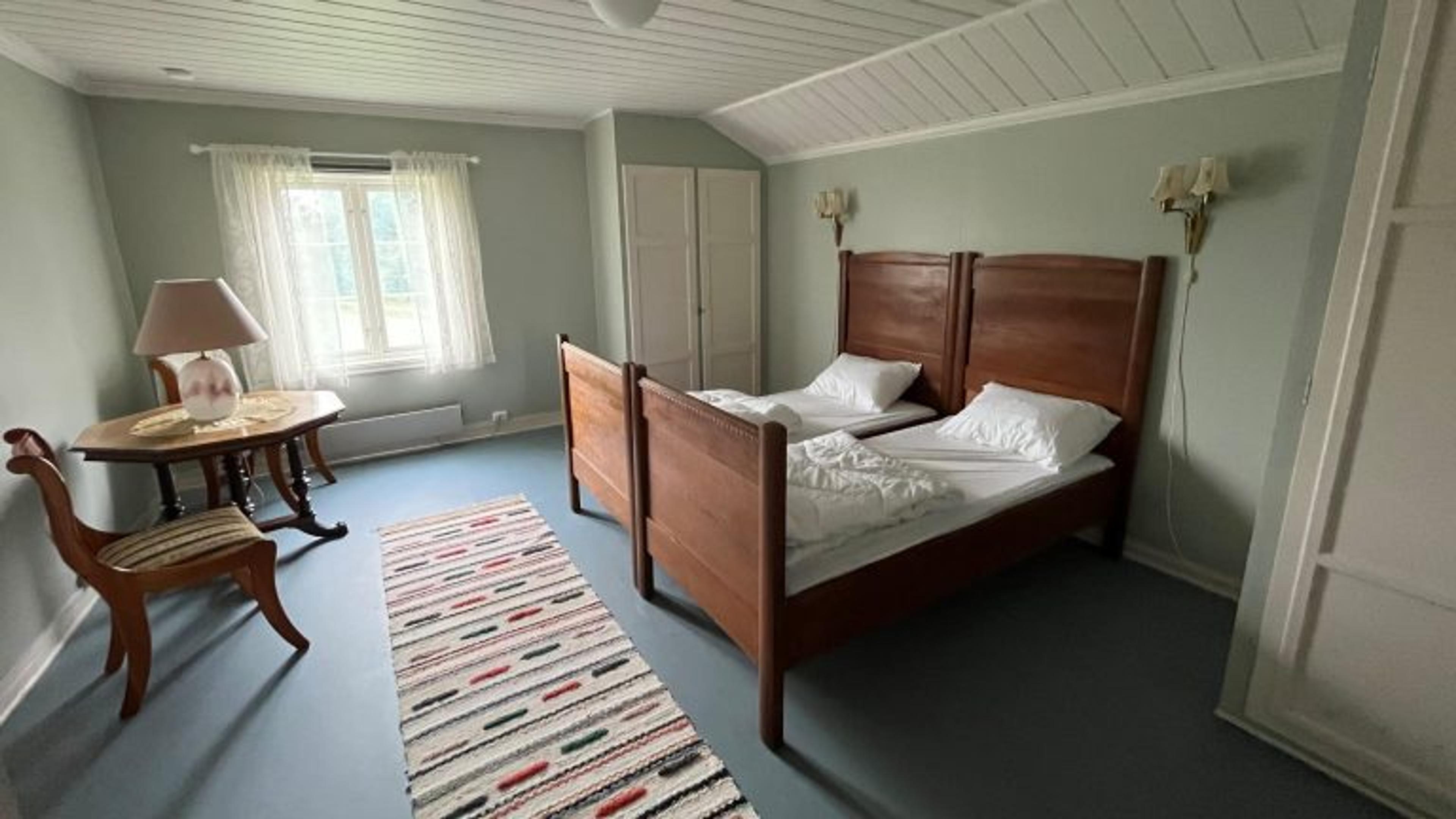 Et soverom med dobbeltseng og møbler